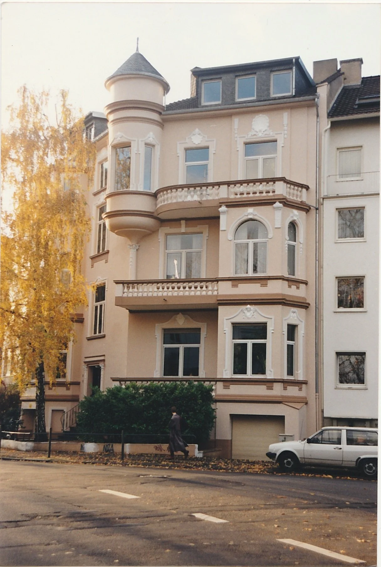 Elegant residential building with rounded corner tower and decorative balconies.
