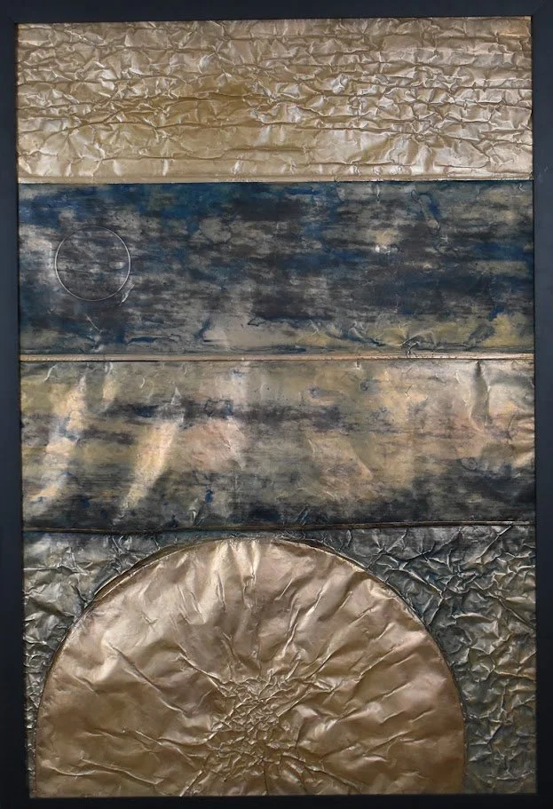 A golden orb rises beneath layered bands of dark blue and metallic gold. Shown close up in a black frame.