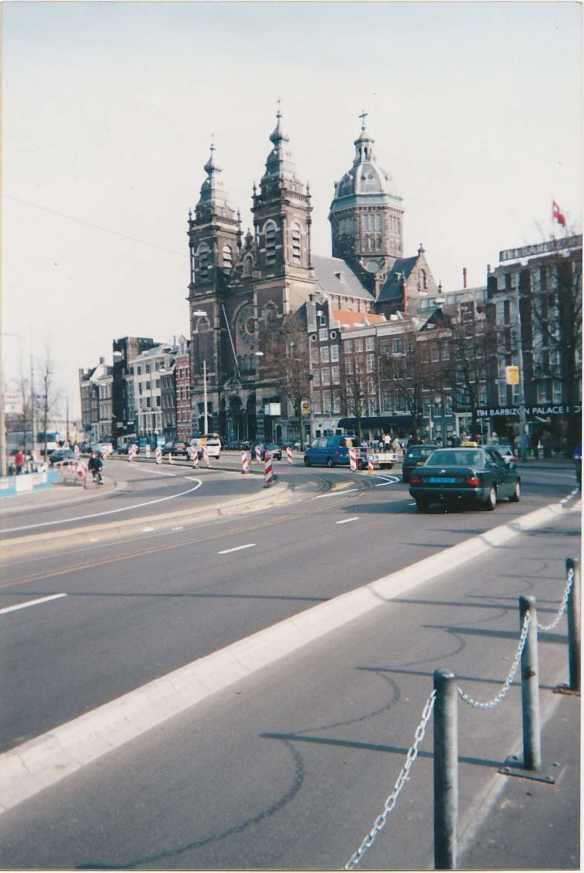 Broad city avenue leading toward a monumental church and historic buildings.