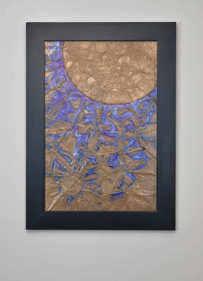 Golden orbs emerge through vivid blue currents. Displayed framed on a white wall.