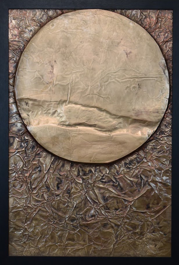A golden orb floats within a textured bronze field. Shown close up in a black frame.