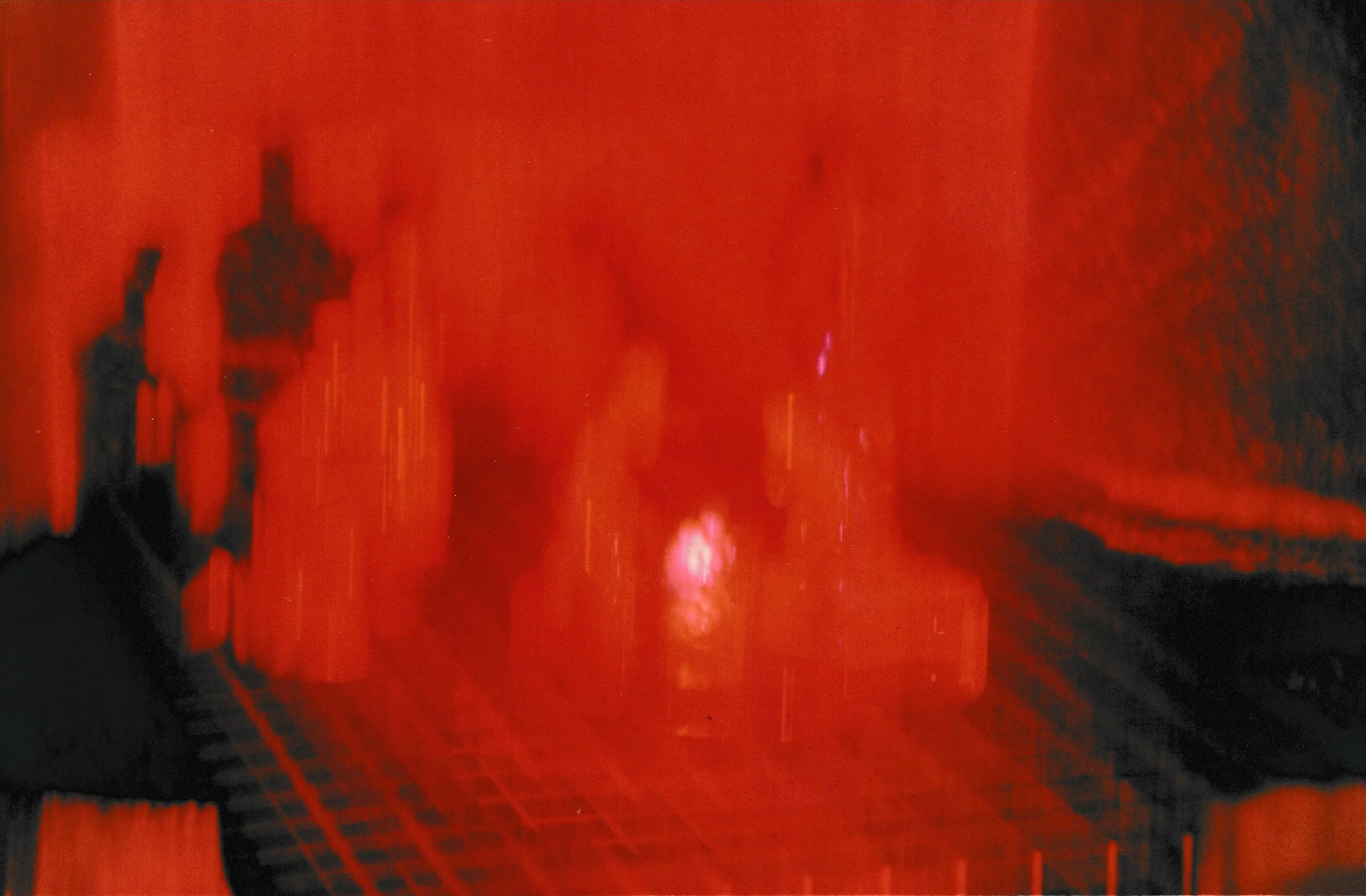 Abstract figures outlined by red light trails against a dark background, creating luminous human-like silhouettes.