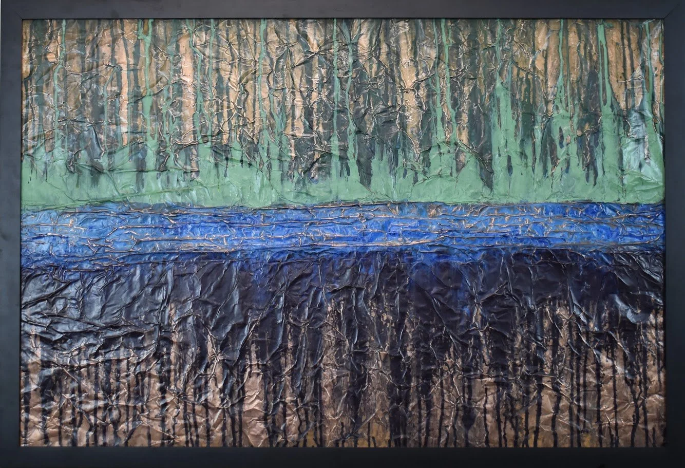 Layered bands of green, blue, and black evoke a distant abstract landscape. Shown close up in a black frame.