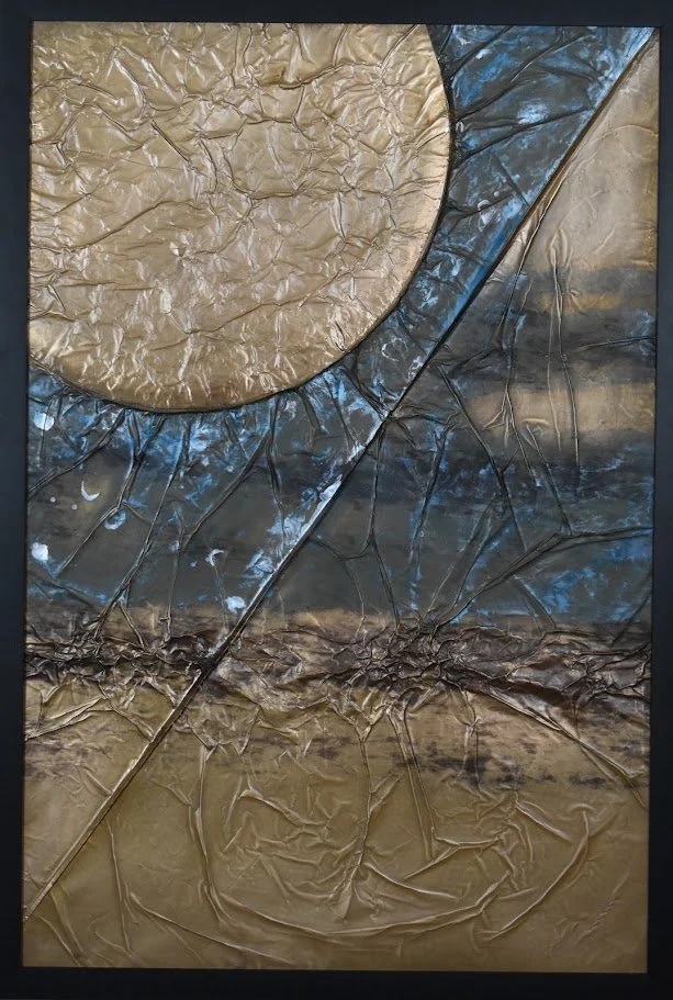 A golden orb intersects sweeping blue and metallic planes. Shown close up in a black frame.