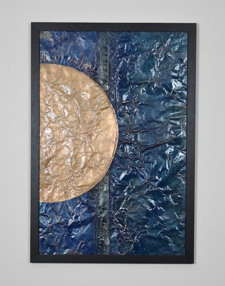 A golden orb emerges against a deep blue metallic field. Displayed framed on a white