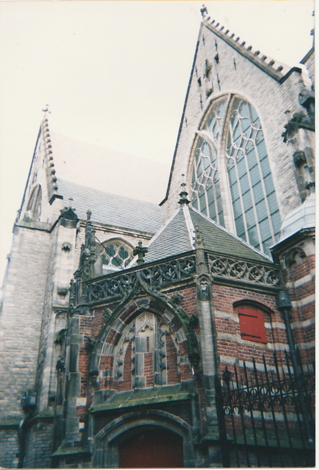 Gothic church façade featuring pointed arches and large stained-glass windows.