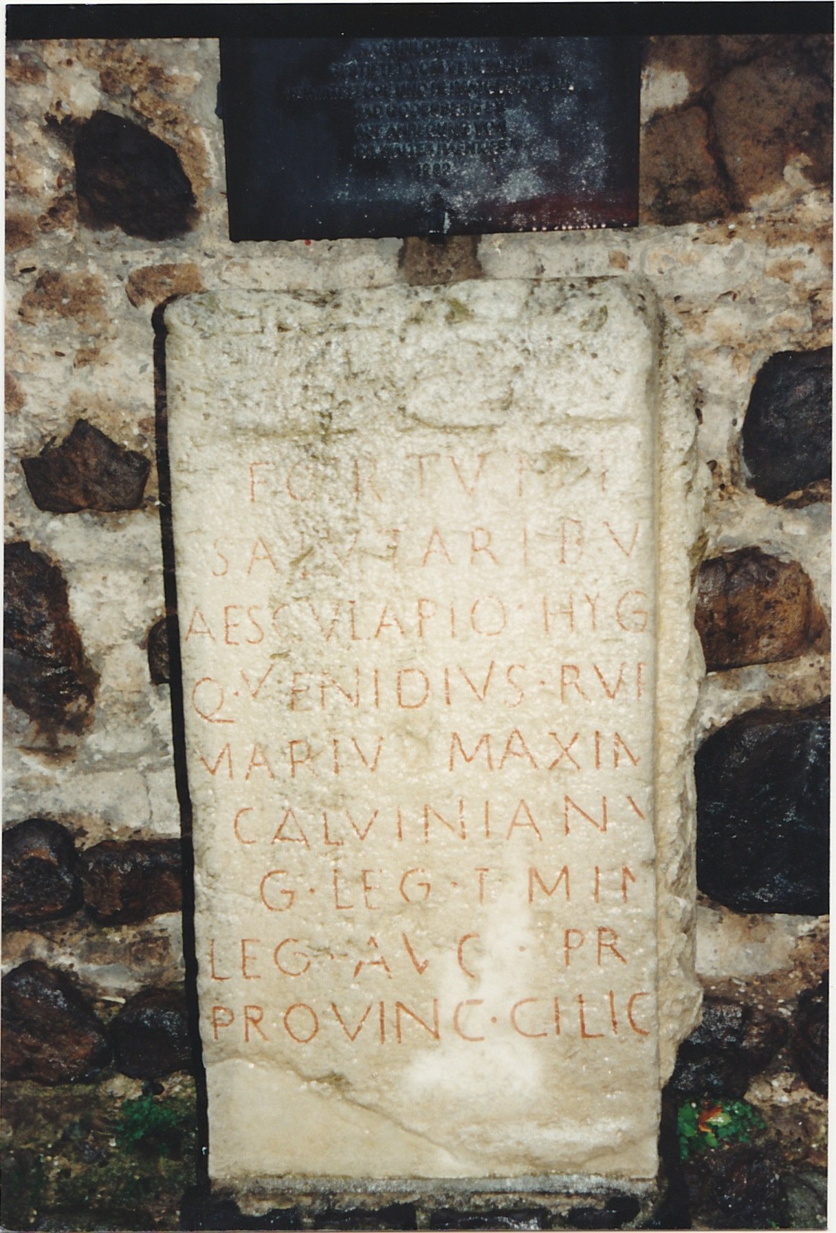 Ancient stone inscription mounted within a weathered wall.