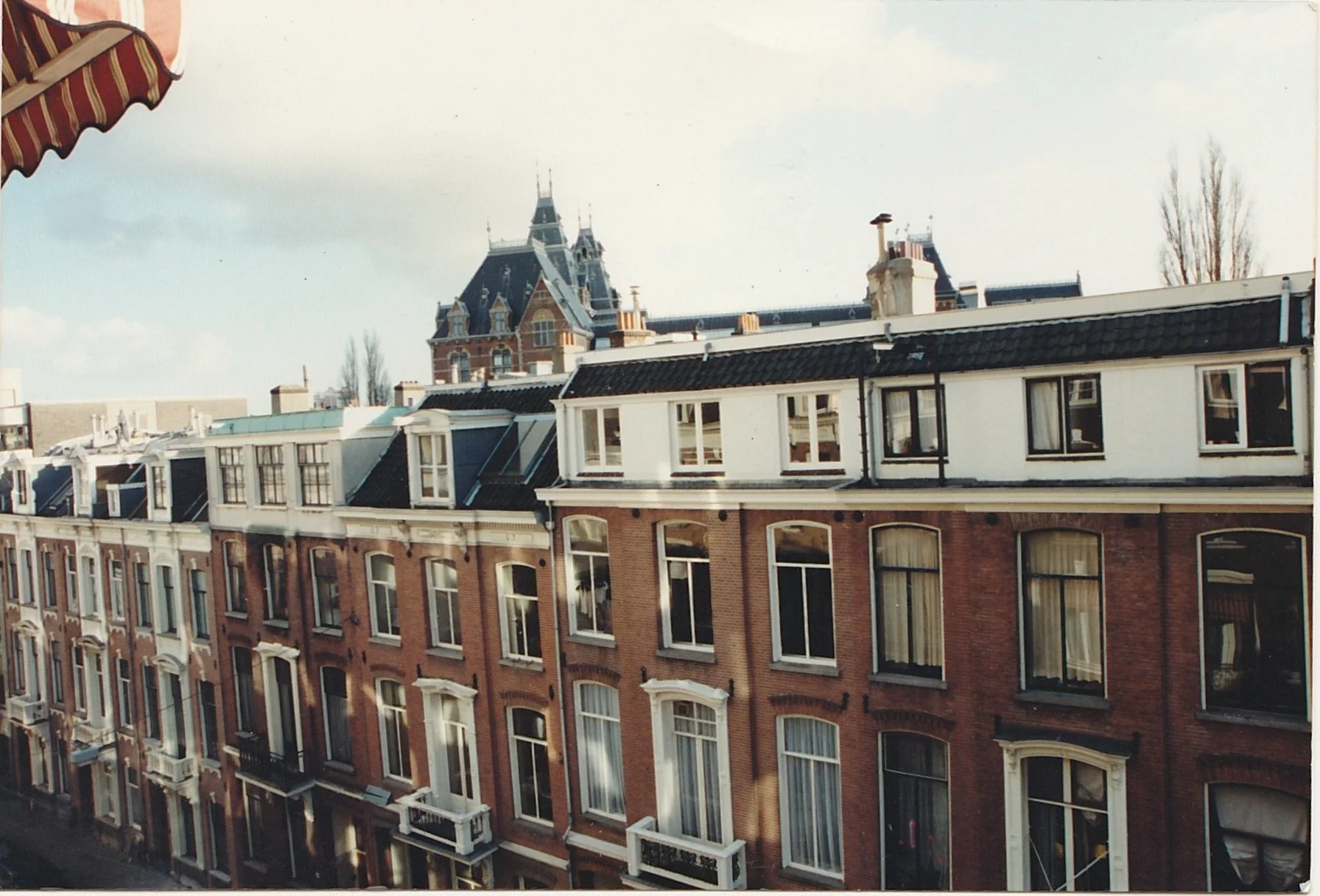 Rooftop view across rows of historic townhouses and distant city landmarks.
