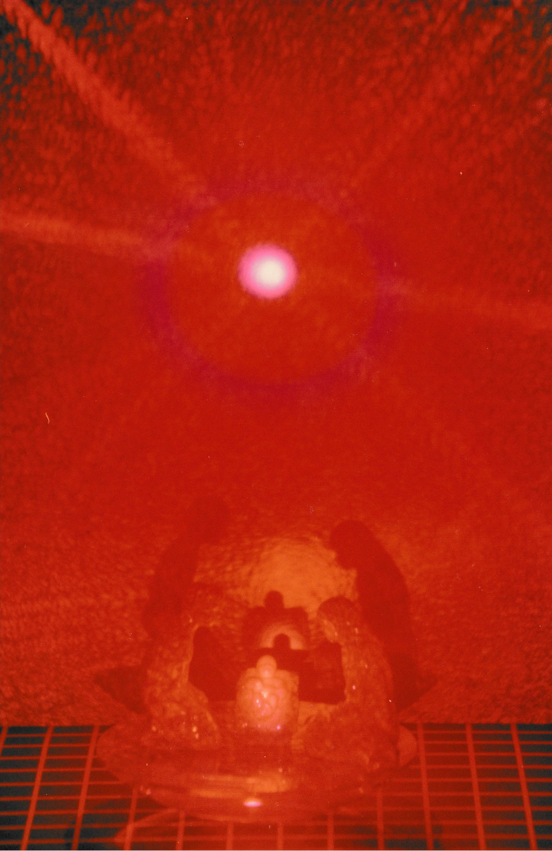 Abstract red environment featuring a glowing oval form suspended above a dark geometric plane.