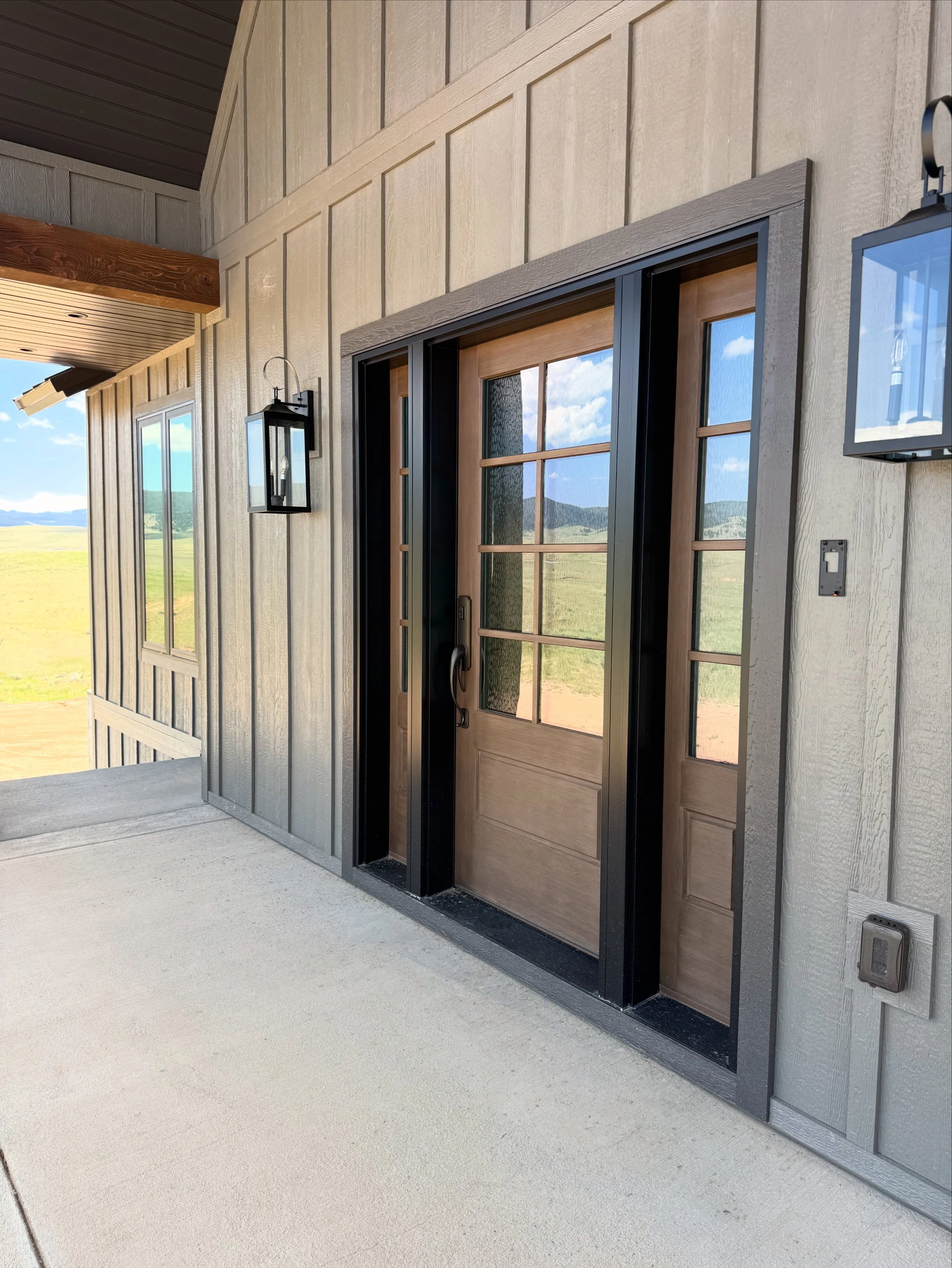 Custom exterior door entry with timber frame surround — luxury Montana home by Mihelich Custom Builders near Butte, MT.