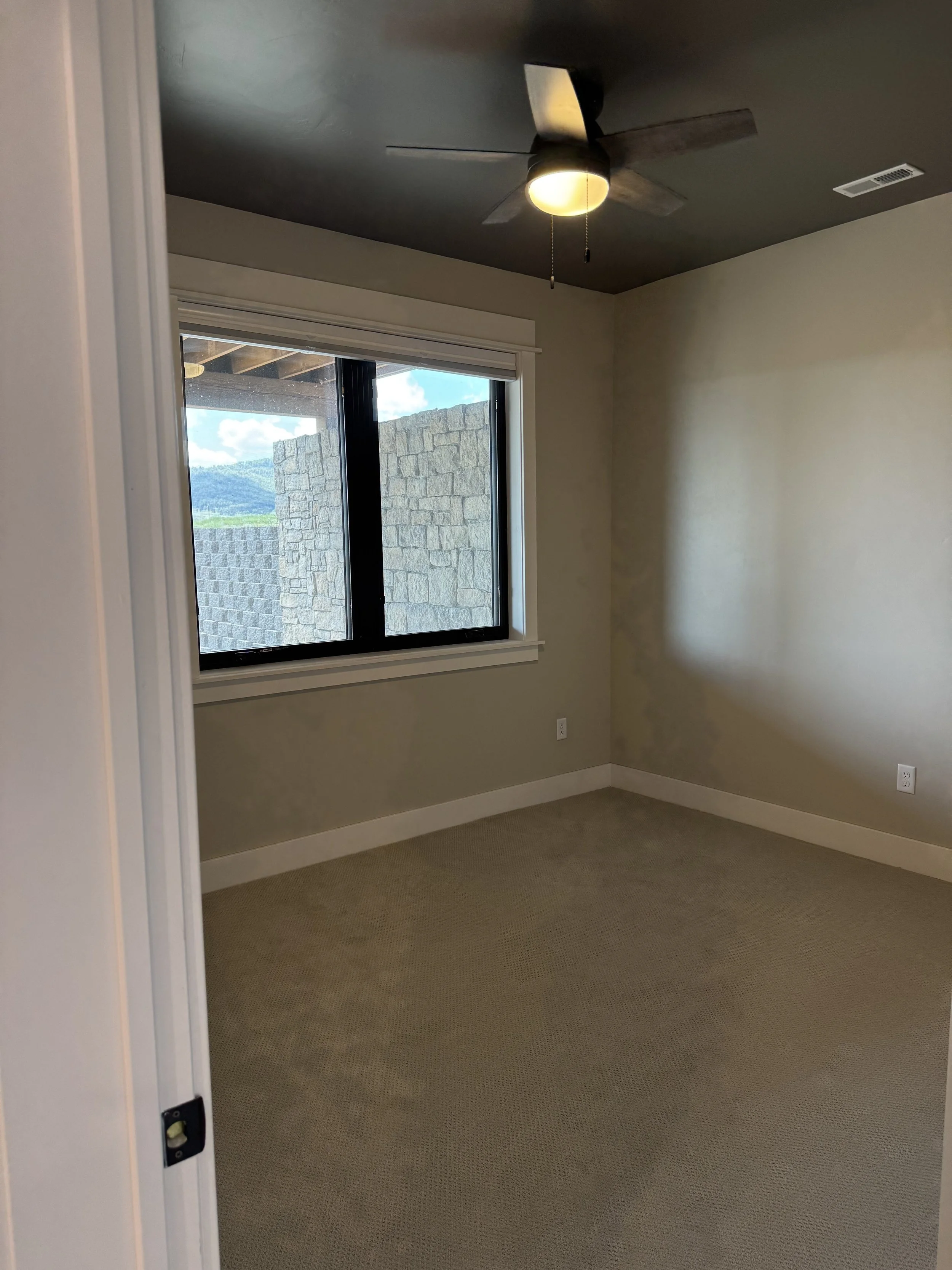 Custom bedroom with plush carpet and quality window package — luxury Montana mountain home by Mihelich Custom Builders near Butte.