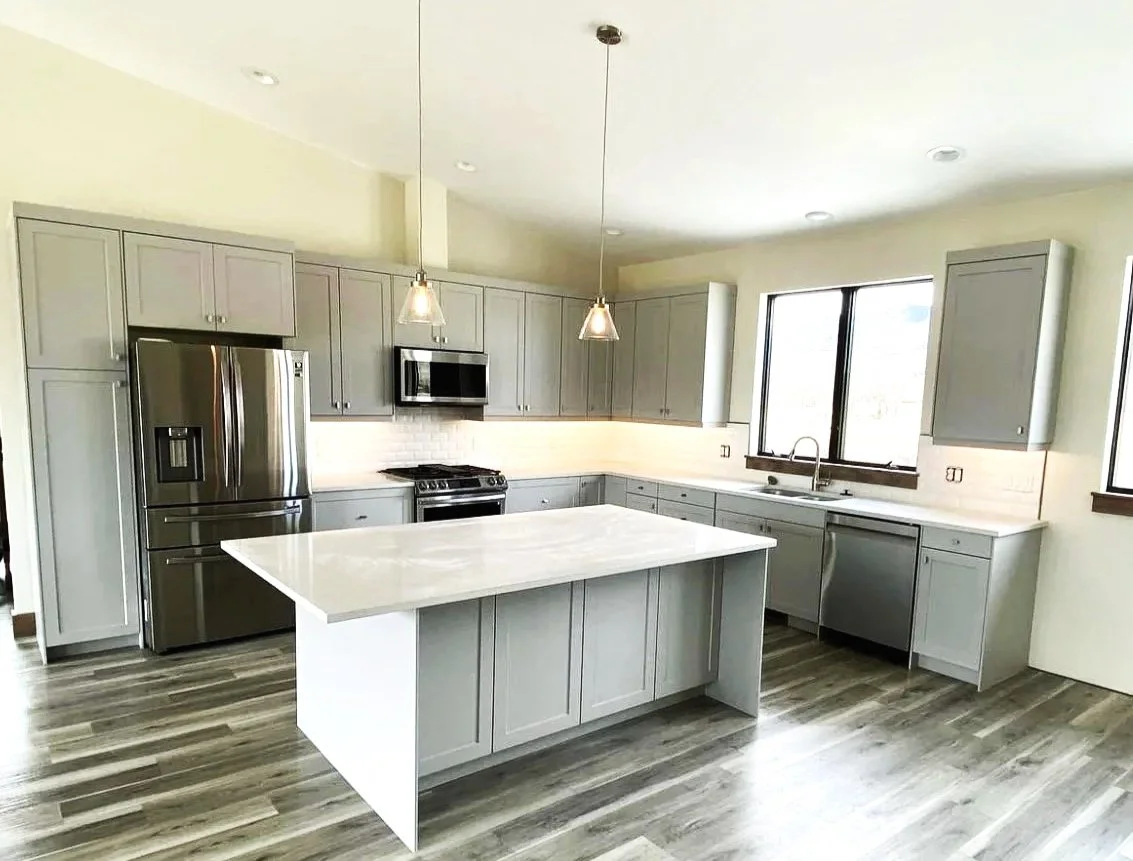 Custom kitchen in the River Barndominium build in Silver Star, Montana -- featuring a large center island, custom cabinetry, and modern finishes crafted by Mihelich Custom Builders.