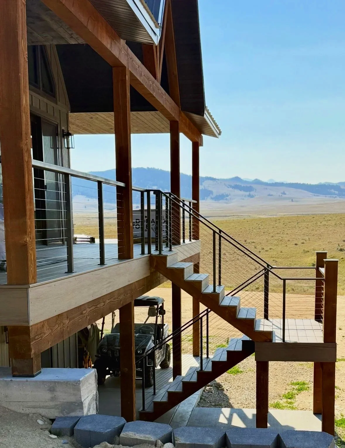 Custom deck with metal railing overlooking Montana mountain views — outdoor living spaces by Mihelich Custom Builders near Butte, MT.