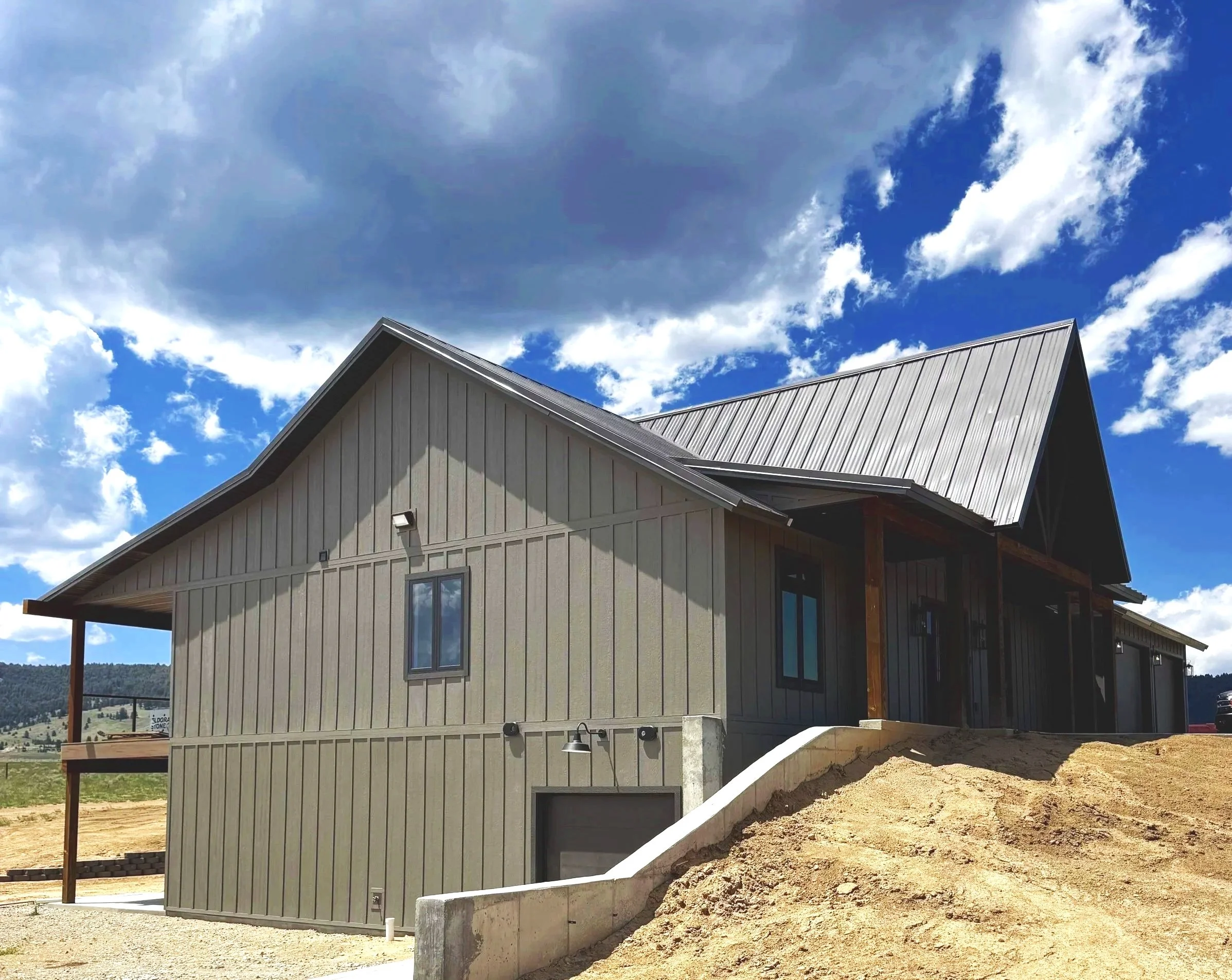 Custom Montana mountain home exterior with metal roof and open sky — luxury home builder Mihelich Custom Builders, Buxton, MT.