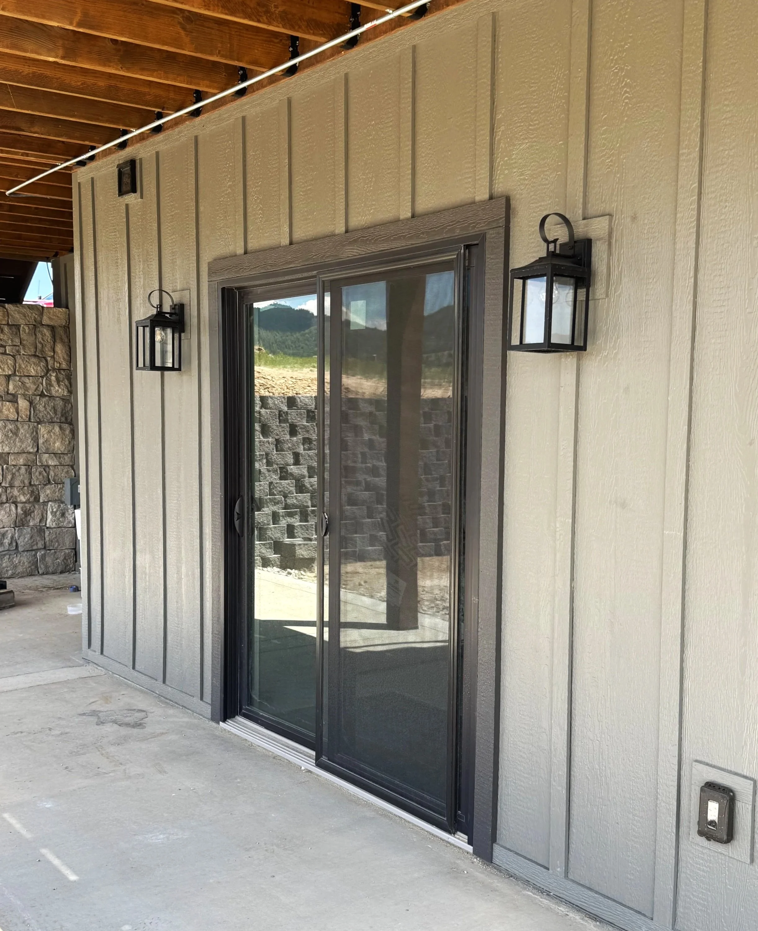 Custom home entry with timber framing and designer lighting — luxury Montana home construction near Butte by Mihelich Custom Builders.
