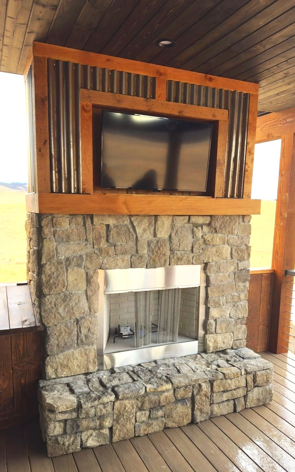 Custom stone hearth and fireplace surround in luxury Montana mountain home — built by Mihelich Custom Builders, Buxton, MT.