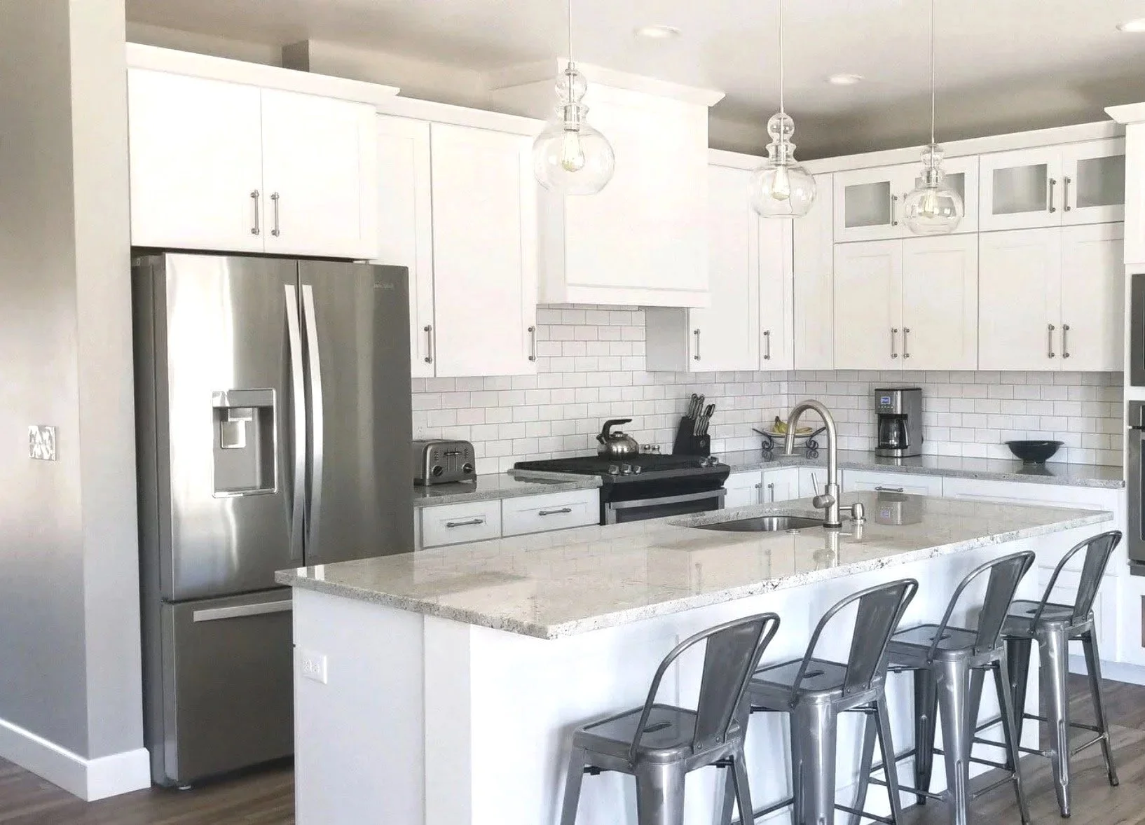 Custom kitchen with large island, bar seating, and premium finishes — luxury custom home by Mihelich Custom Builders, Butte, Montana.
