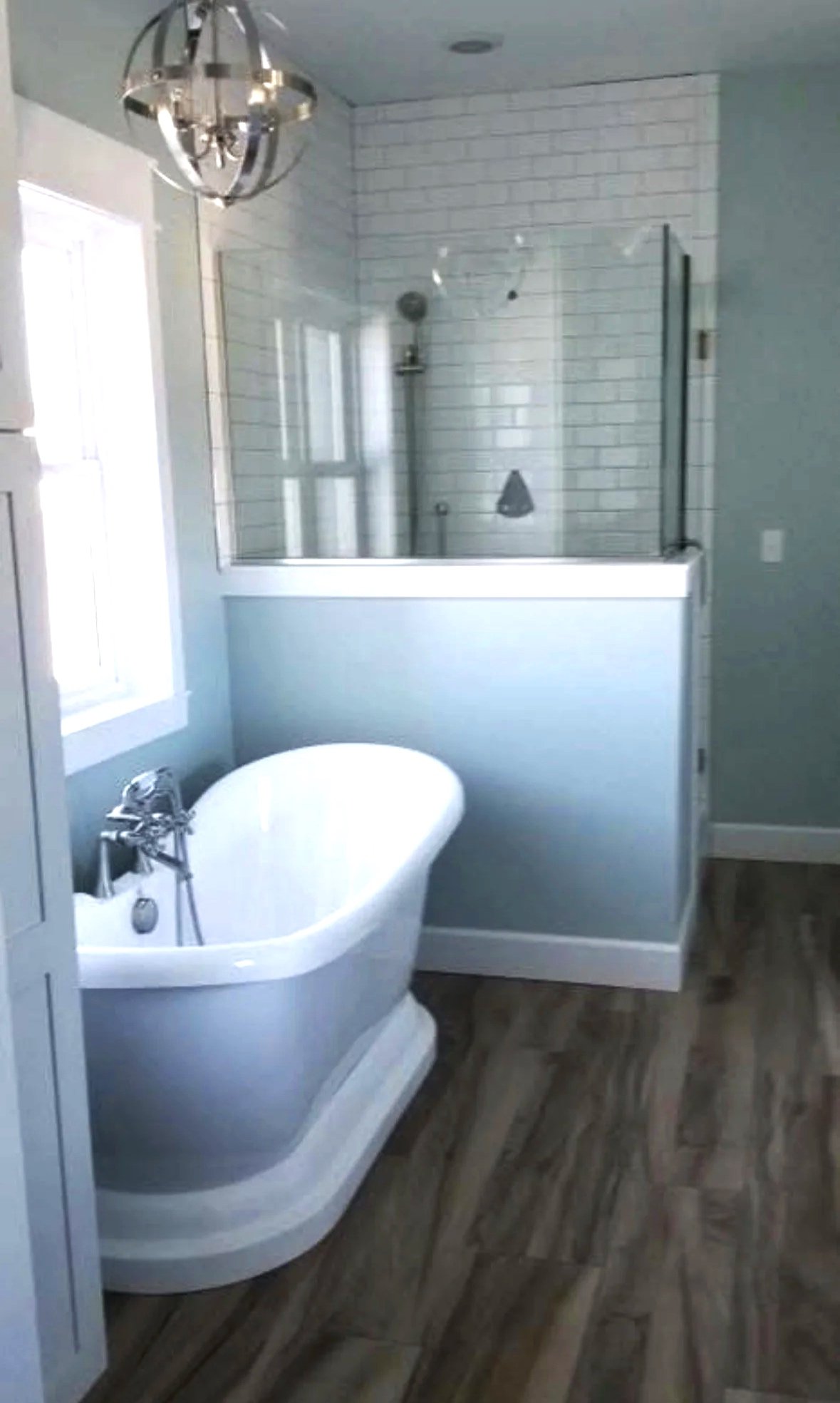 Custom bathroom with freestanding soaking tub and designer tile surround — luxury home construction in Butte, MT by Mihelich Custom Builders.