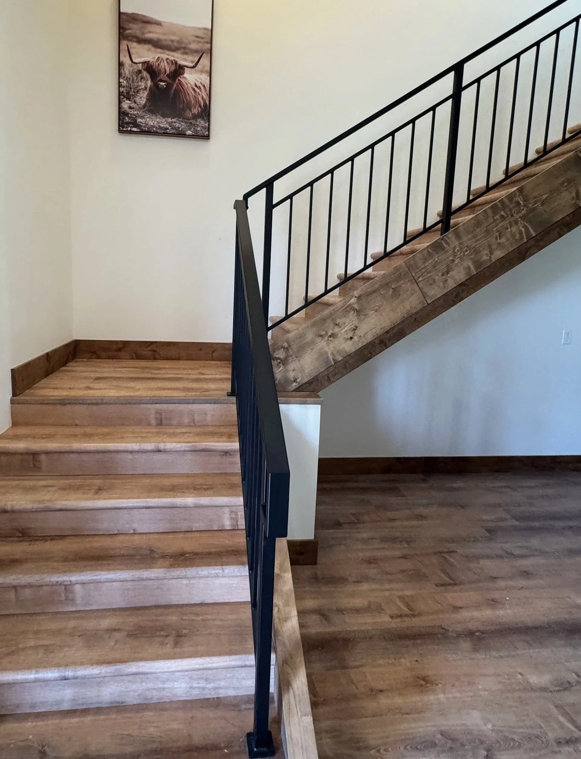 Custom staircase landing with hardwood floors and natural light — rustic luxury home by Mihelich Custom Builders, Glen, Montana.