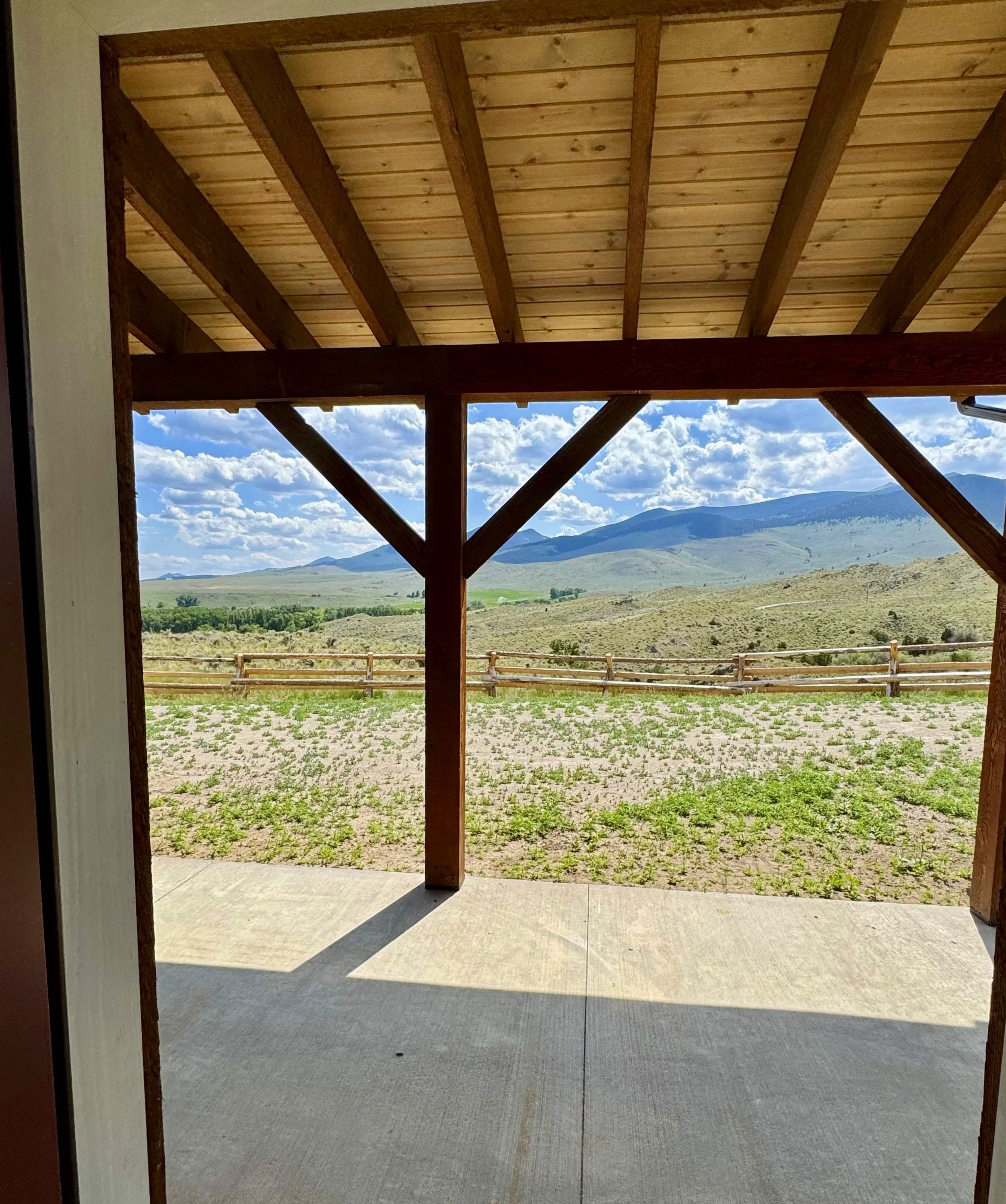 Custom covered porch with panoramic Montana valley views — outdoor living by Mihelich Custom Builders, Glen, MT.