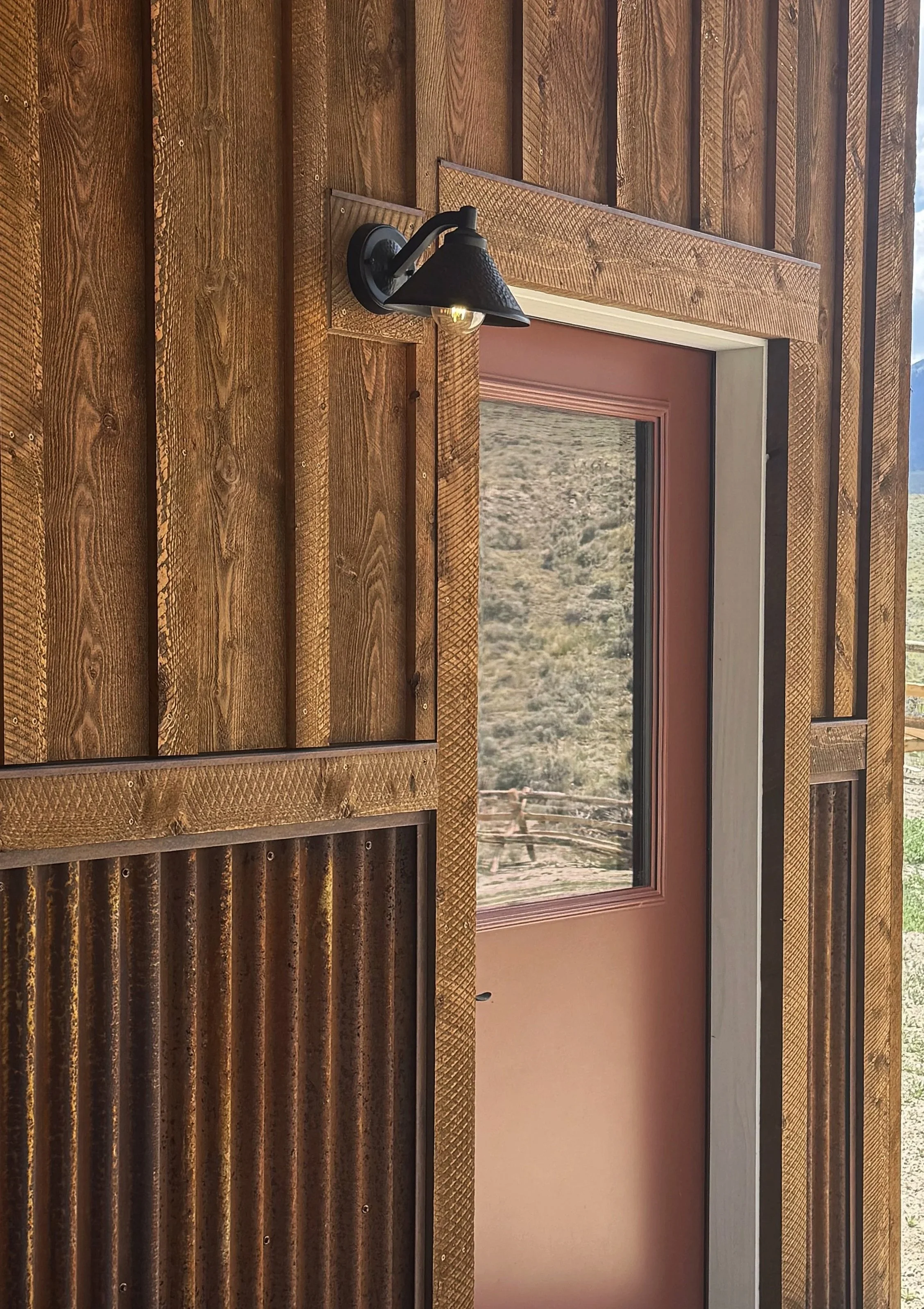 Custom bold red entry door with natural wood surround — signature detail by Mihelich Custom Builders, Glen, MT.
