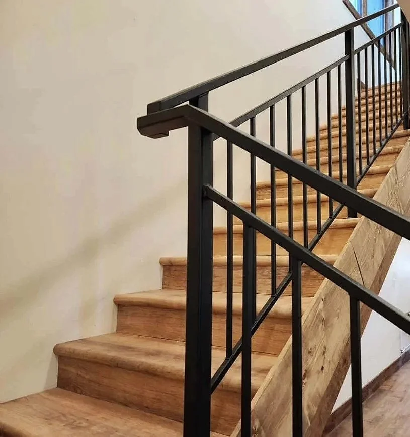 Custom interior staircase with wood treads and black metal railing — luxury rustic home by Mihelich Custom Builders, Glen, Montana.