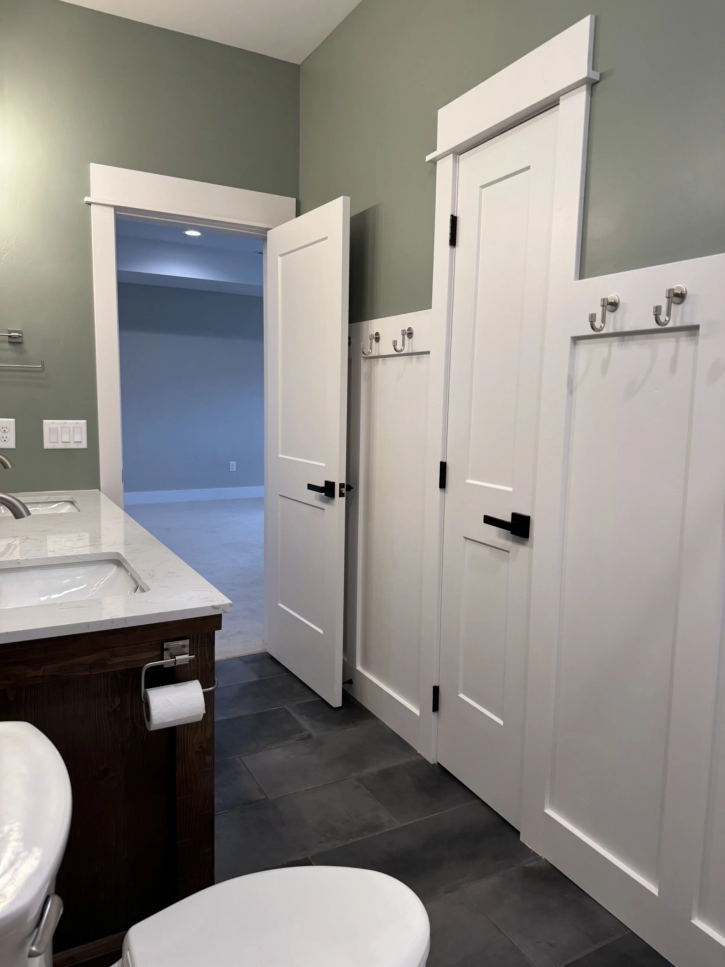 Custom bathroom with dark cabinetry and designer fixtures — luxury Montana home construction near Butte by Mihelich Custom Builders.