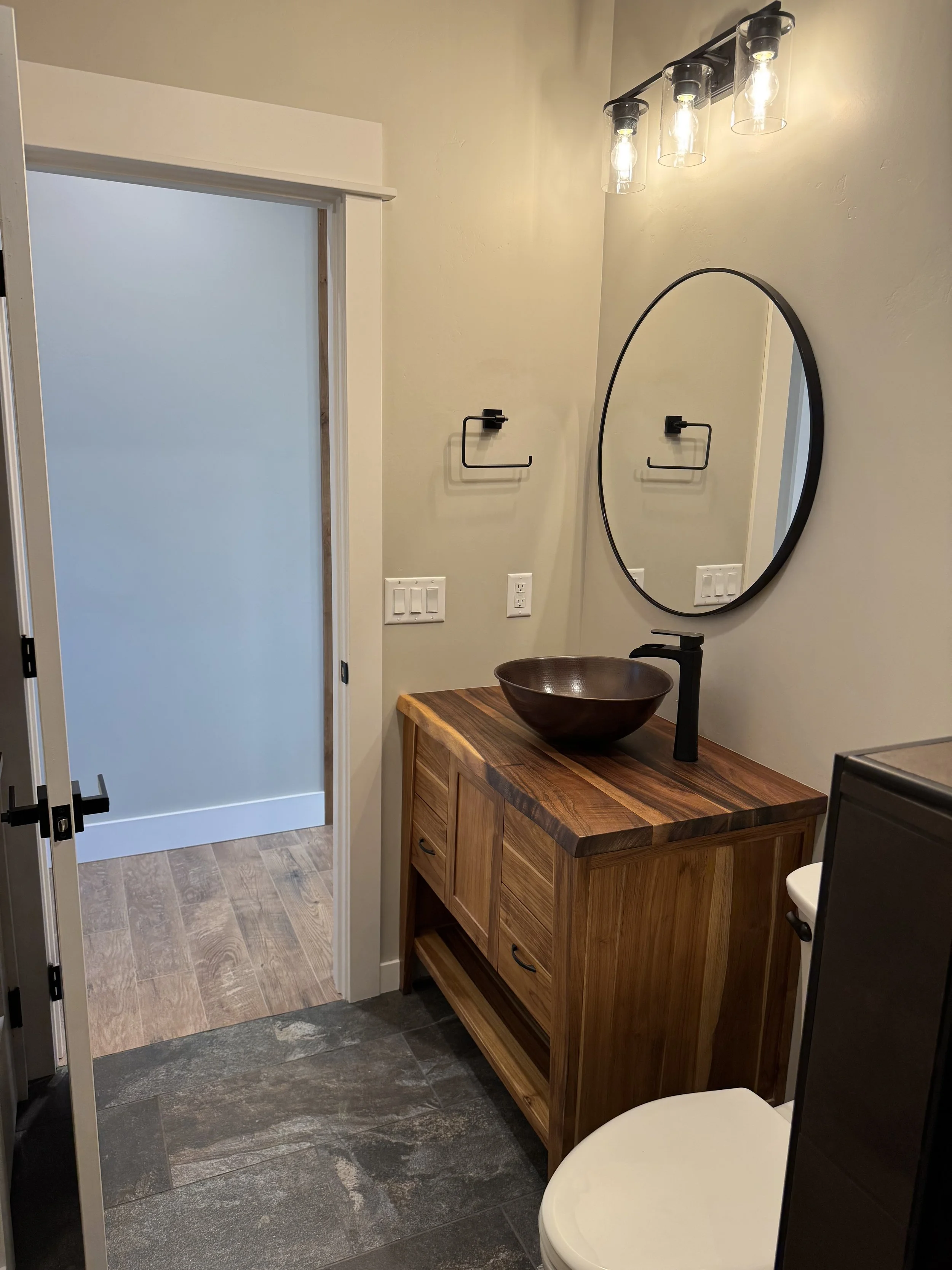 Custom bathroom with vessel sink and wood vanity — designer bathroom finishes by Mihelich Custom Builders near Butte, MT.