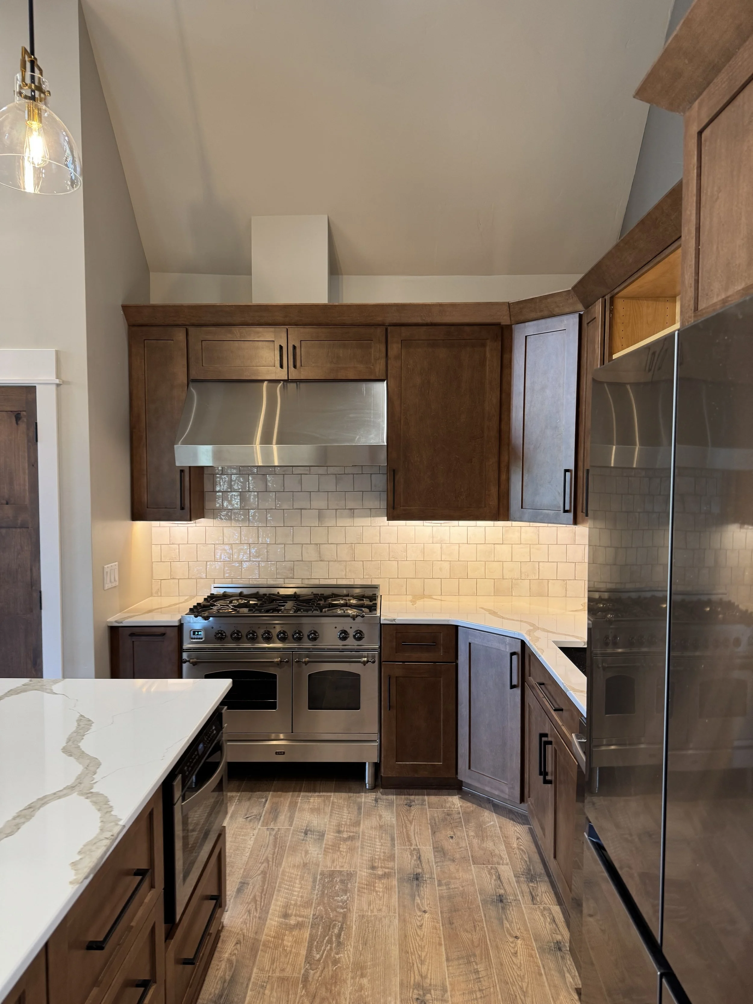 Custom kitchen with professional range, custom hood, and designer cabinetry — luxury home construction by Mihelich Custom Builders near Butte, MT