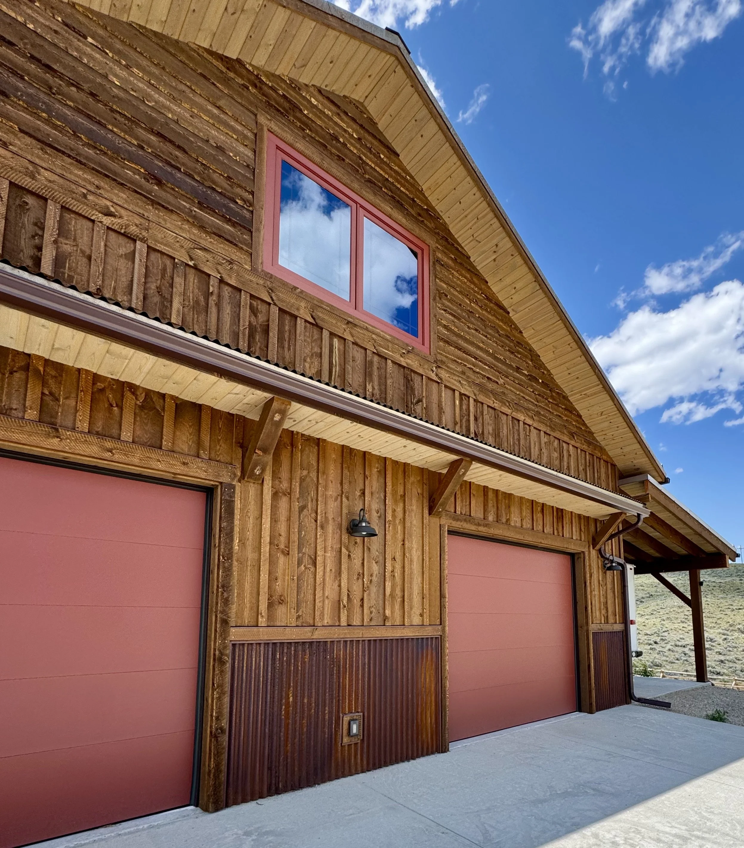 Custom rustic home with attached garage and Montana mountain backdrop — Mihelich Custom Builders, Glen, MT.