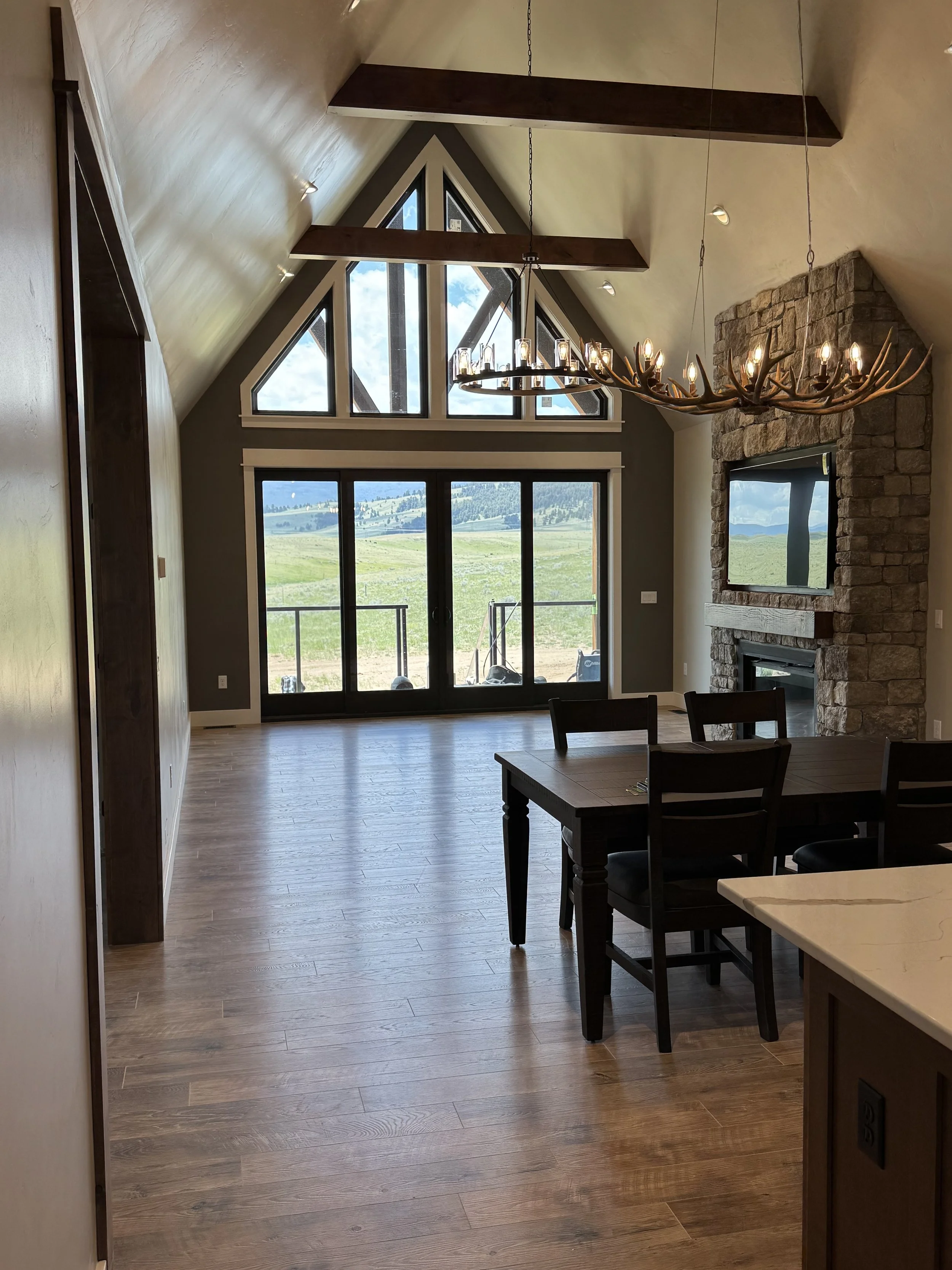 Custom open-concept great room with stone fireplace and gourmet kitchen — luxury Montana home by Mihelich Custom Builders near Butte, MT.