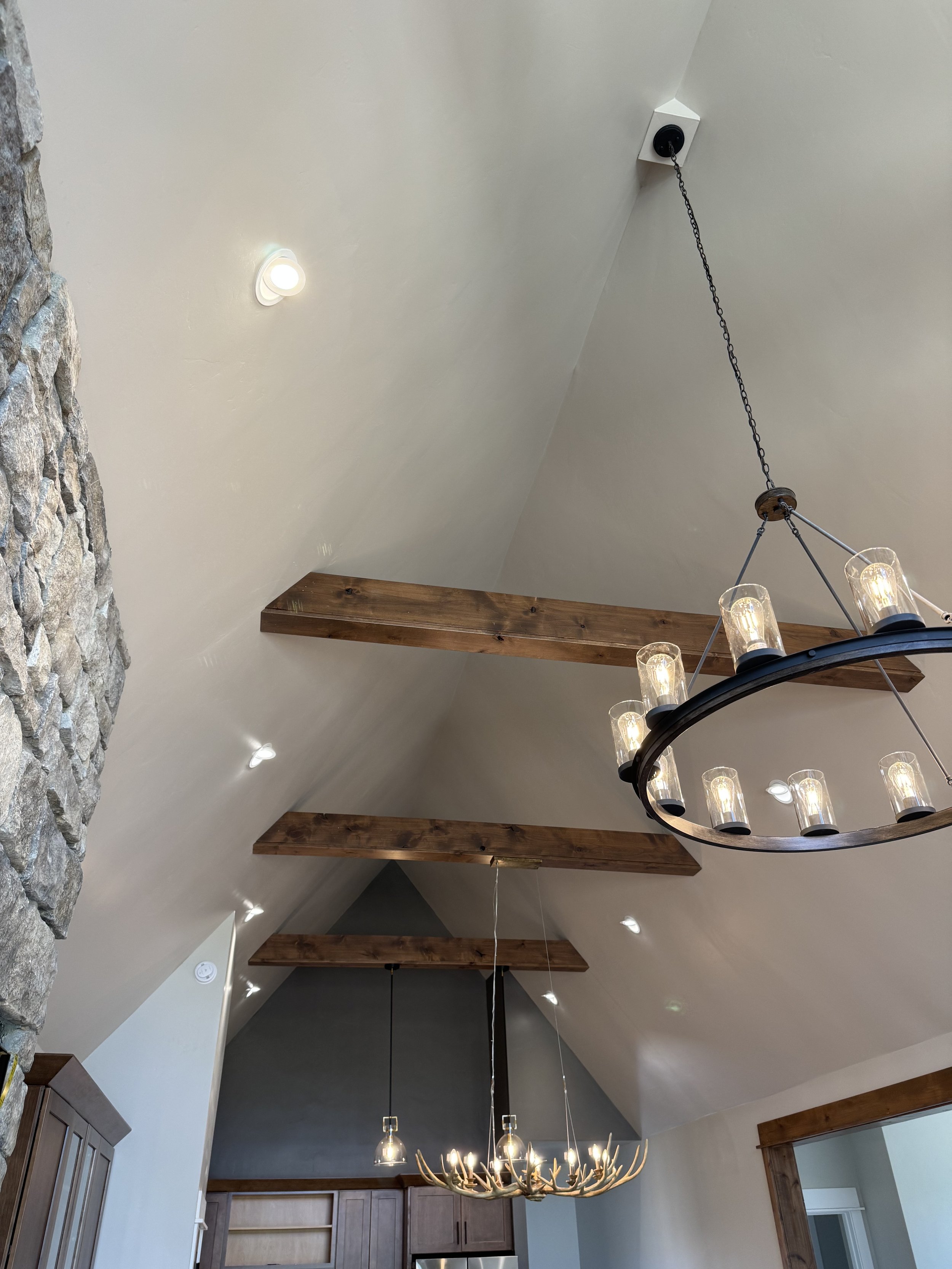 Custom great room with statement chandelier and vaulted timber ceiling — luxury Montana home by Mihelich Custom Builders near Butte, MT.