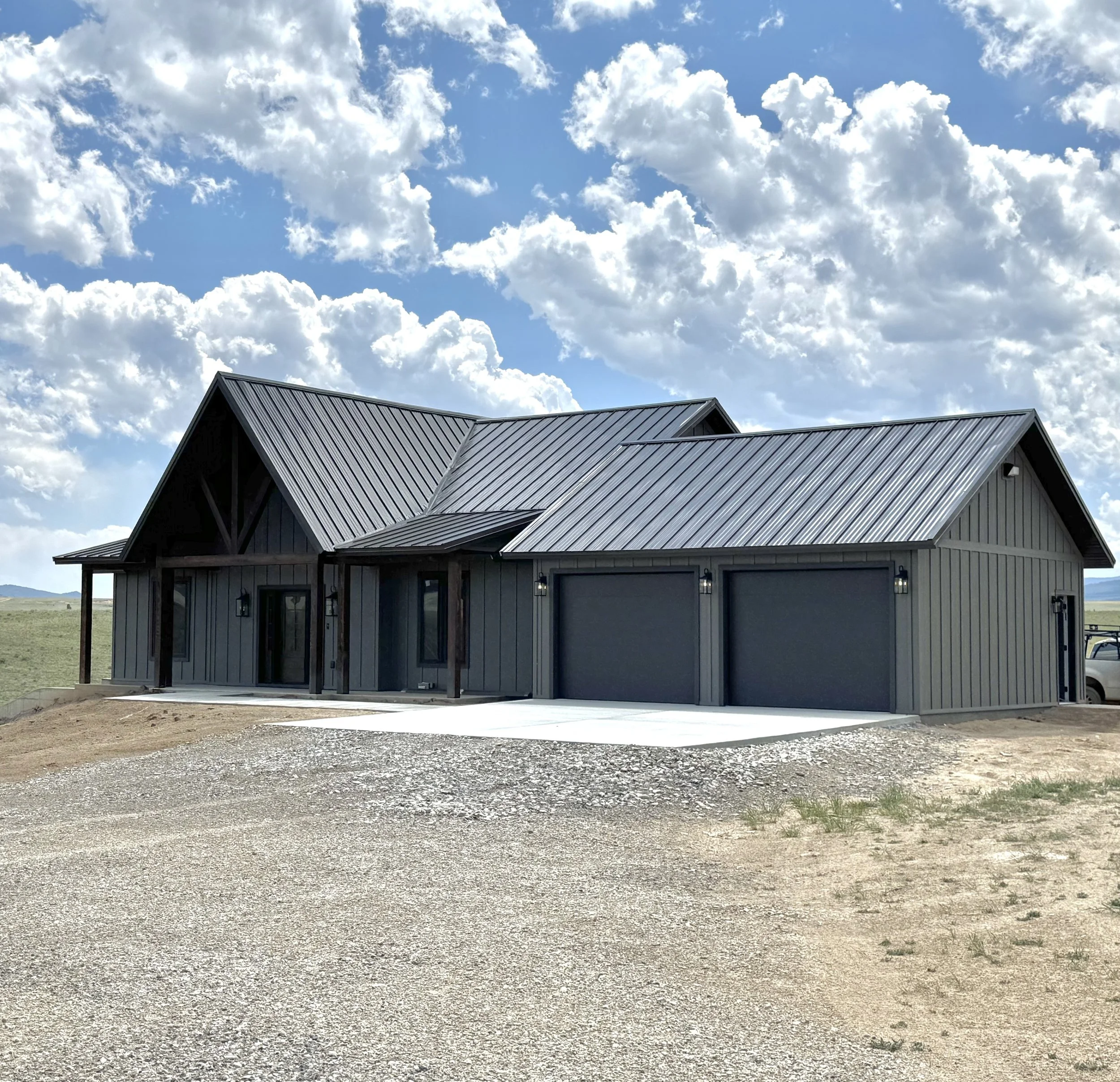 Custom timber frame home exterior under dramatic Montana sky — luxury mountain home construction near Butte by Mihelich Custom Builders.