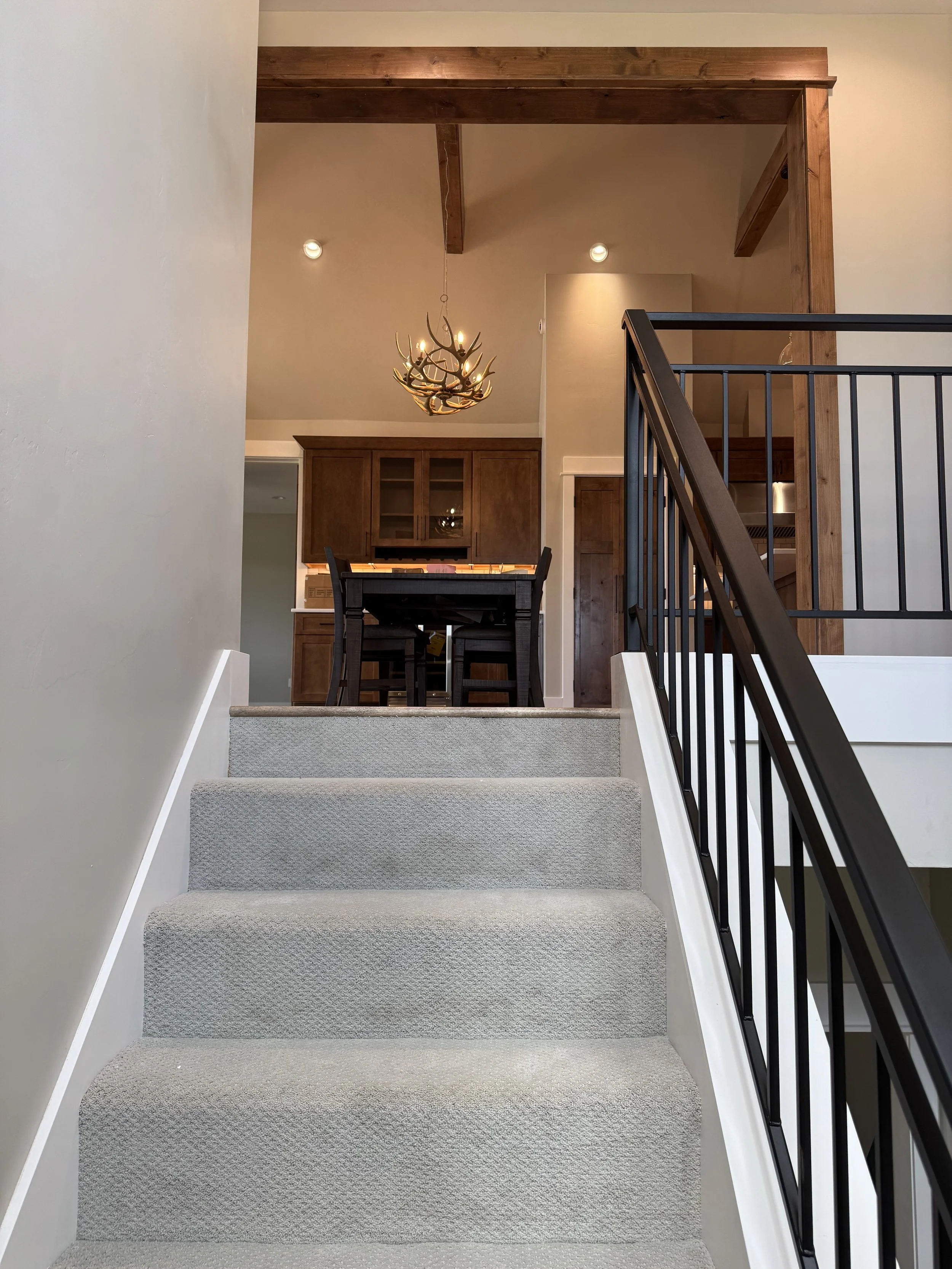 Custom staircase with metal railing — high-end interior craftsmanship by Mihelich Custom Builders near Butte, MT.