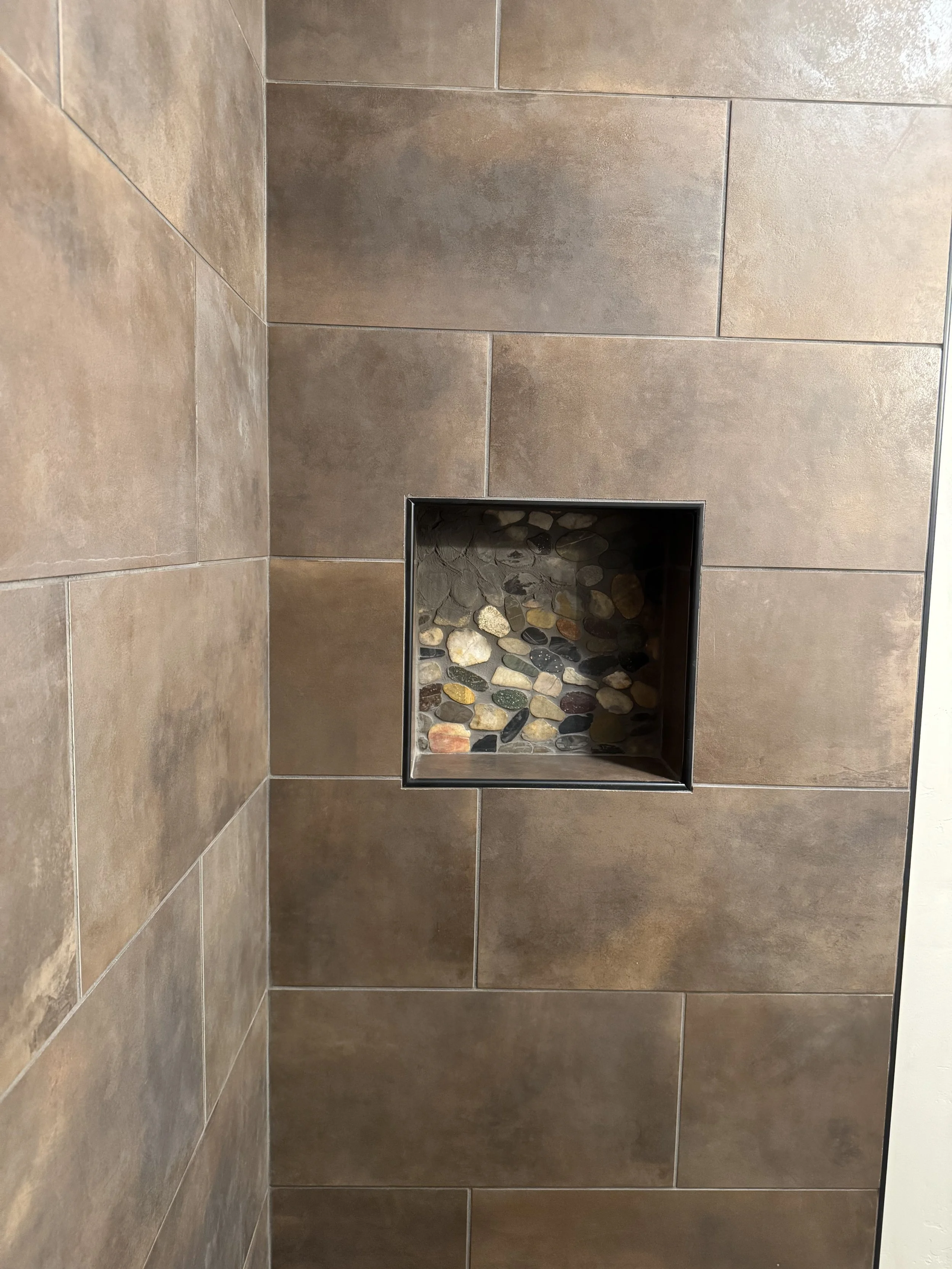 Custom stone shower with decorative niche — spa-quality bathroom by Mihelich Custom Builders, luxury home near Butte, Montana