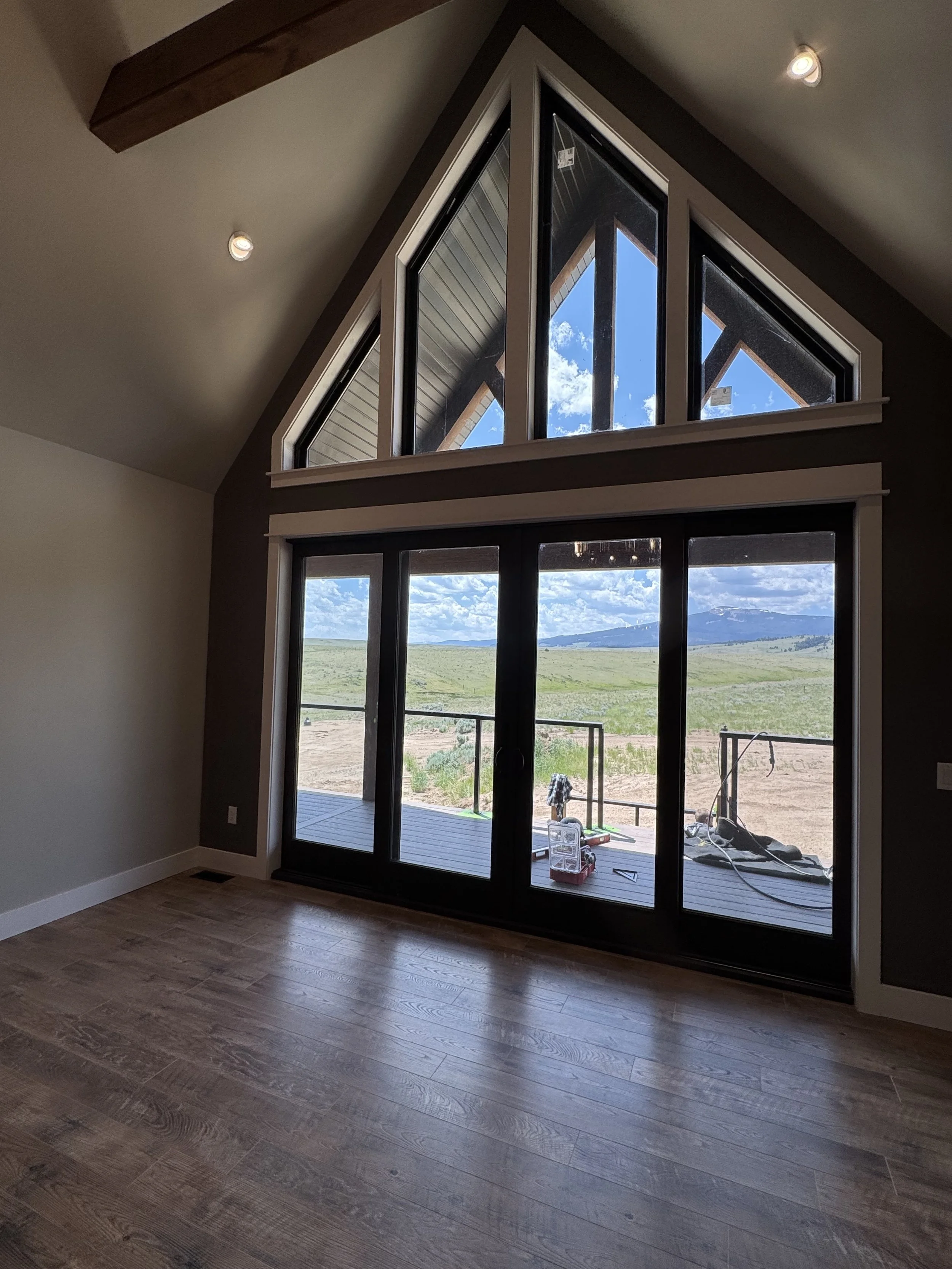 Custom open-concept great room with stone fireplace and gourmet kitchen — luxury Montana home by Mihelich Custom Builders near Butte, MT.