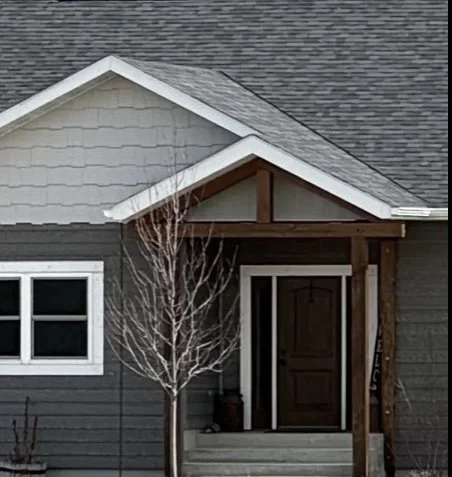 Custom modern home exterior with dark siding and attached garage — Mihelich Custom Builders, Butte, Montana.