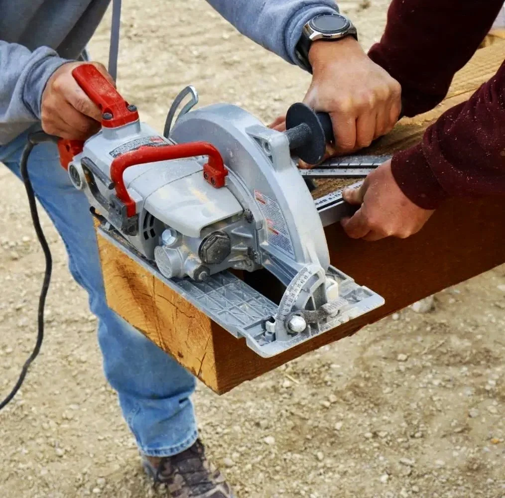 Mihelich Custom Builders crew member cutting lumber on a custom home job site in Montana.