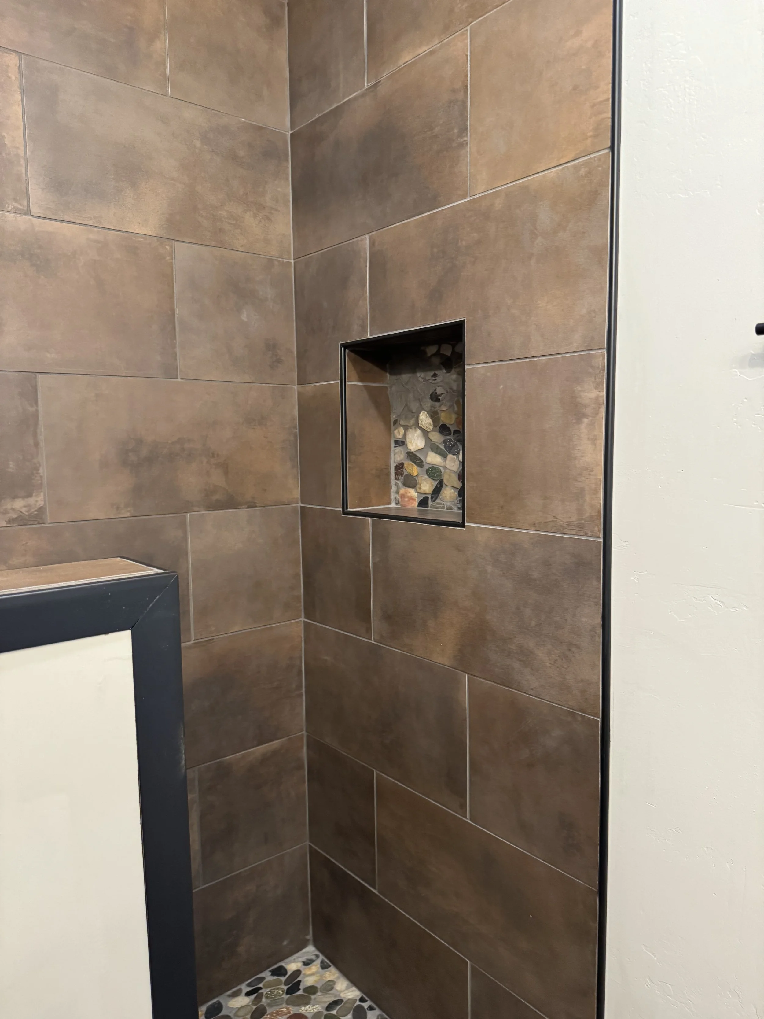 Custom stone shower with decorative niche — spa-quality bathroom by Mihelich Custom Builders, luxury home near Butte, Montana