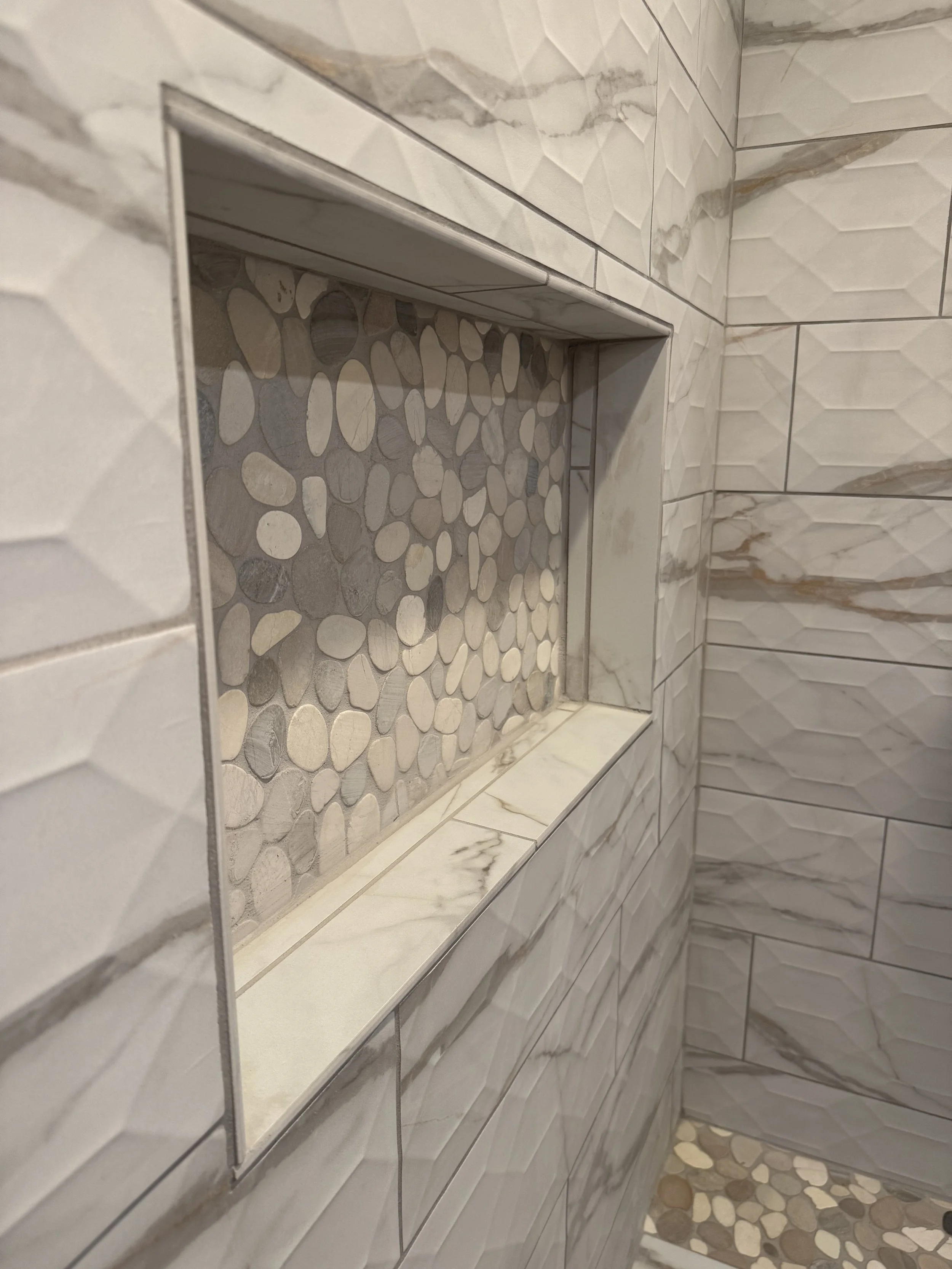 Custom stone feature wall in luxury shower — high-end bathroom construction by Mihelich Custom Builders near Butte, MT.