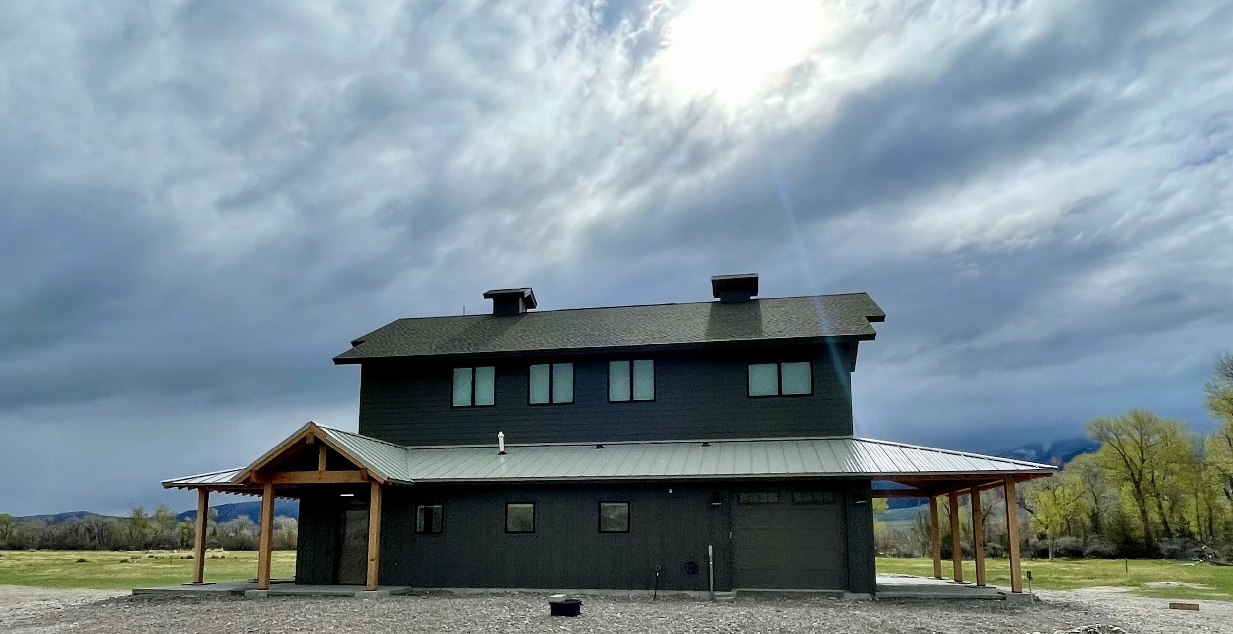 Custom barndominium exterior under a dramatic Montana sky — River Barndominium, Silver Star, MT, built by Mihelich Custom Builders.