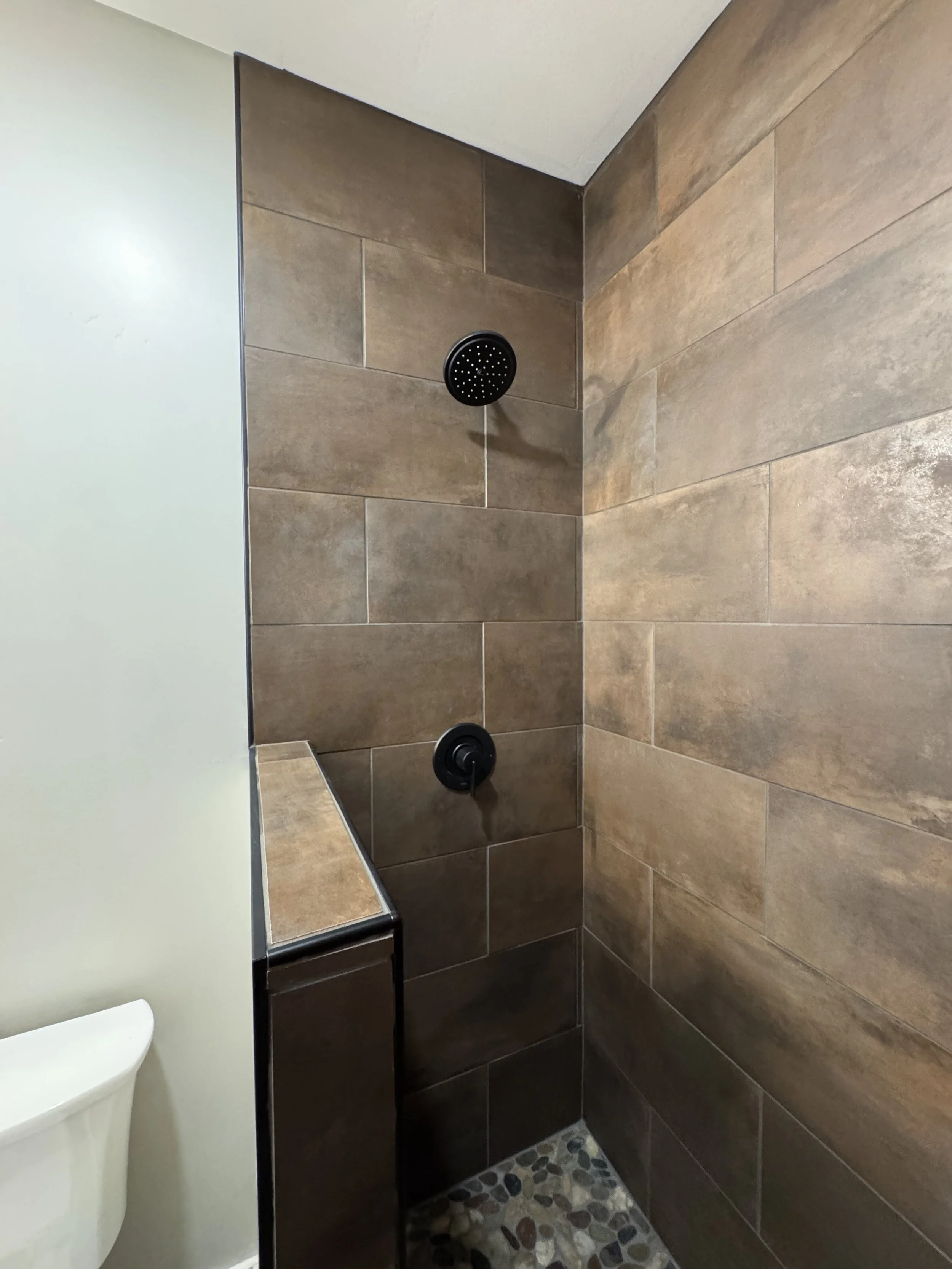 Custom stone tile shower surround — luxury spa bathroom by Mihelich Custom Builders near Butte, Montana.