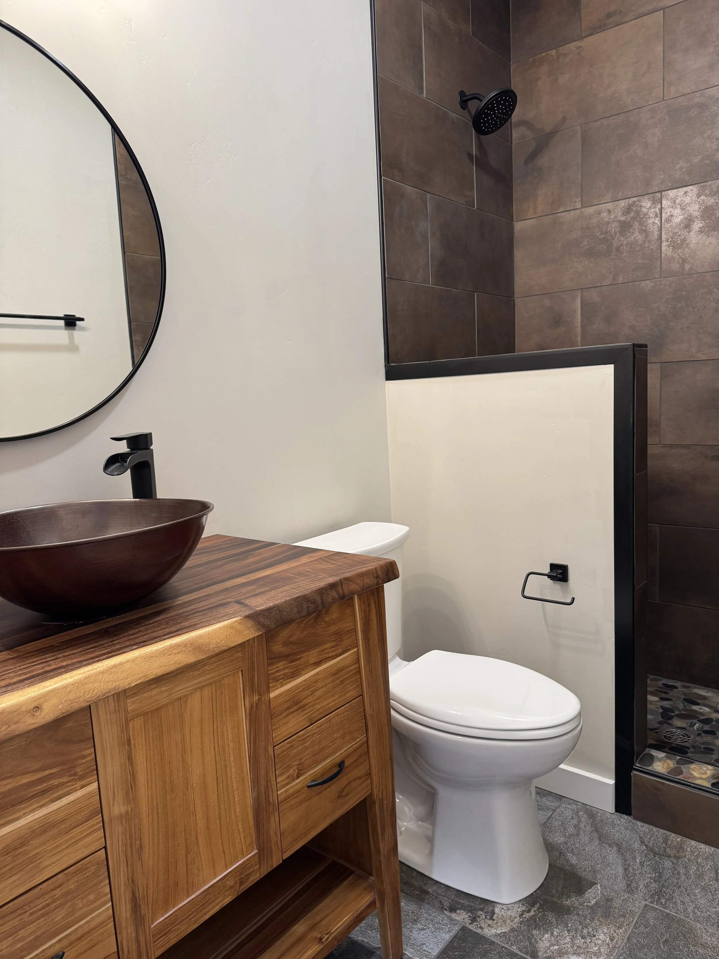 Custom bathroom with vessel sink, wood vanity, and designer fixtures — luxury Montana home builder Mihelich Custom Builders near Butte.