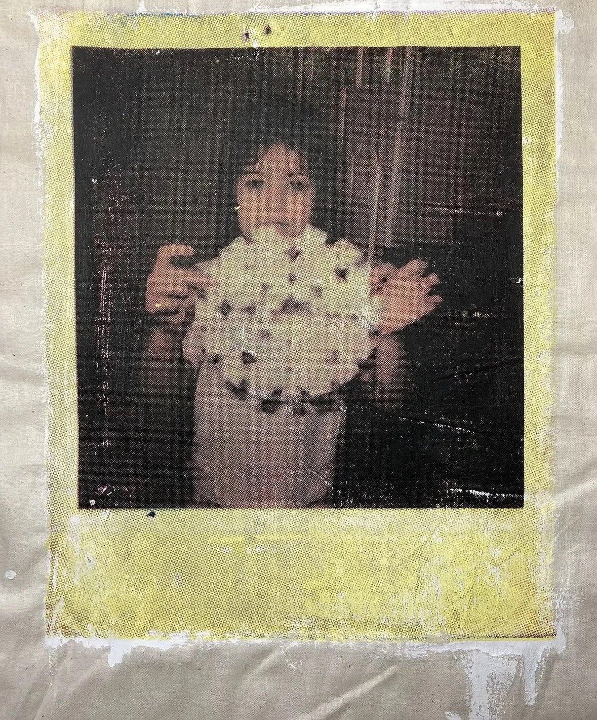 A vintage photo of a woman smiling, holding a bunch of flowers, with a yellow border around the picture.