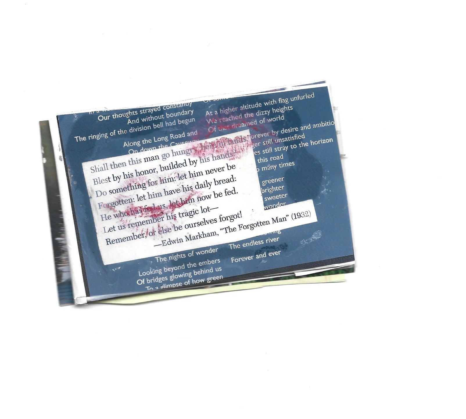 A blurry, slightly damaged booklet featuring text from a poem by Edwin Markham, titled 'The Forgotten Man' (1932), resting on a white background.