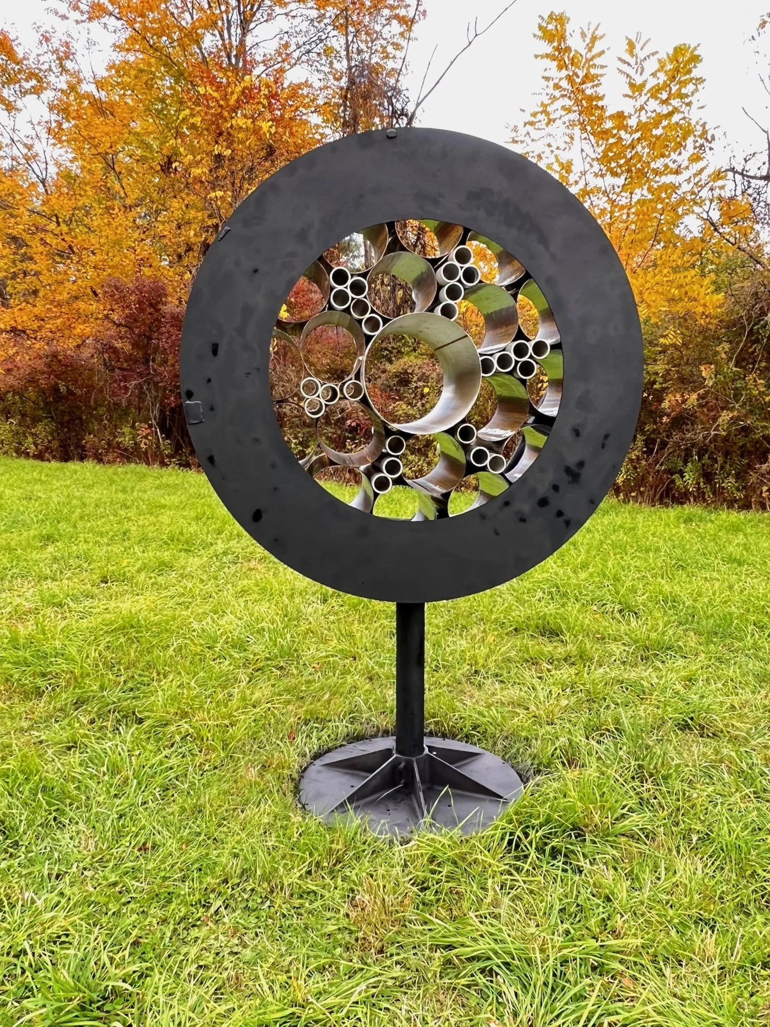 Surveillance - Inspired by the prevalence of monitoring methods that are part of our daily lives. As one drives by this piece, it appears to flicker like it’s taking a photo. Welded steel, stainless steel and aluminum cylinders. 7’5” x 5’ x 30.50”. 2