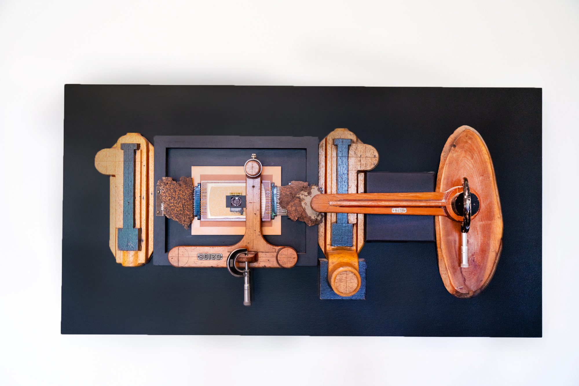 Calibrate -A drive for precise outcome & measurements is the inspiration for this piece. Vintage calipers, wood patterns, rusty steel, paper, electrical components, brass hinges, photo, pocket watch frame. 22” x 42” x 6”, 2014