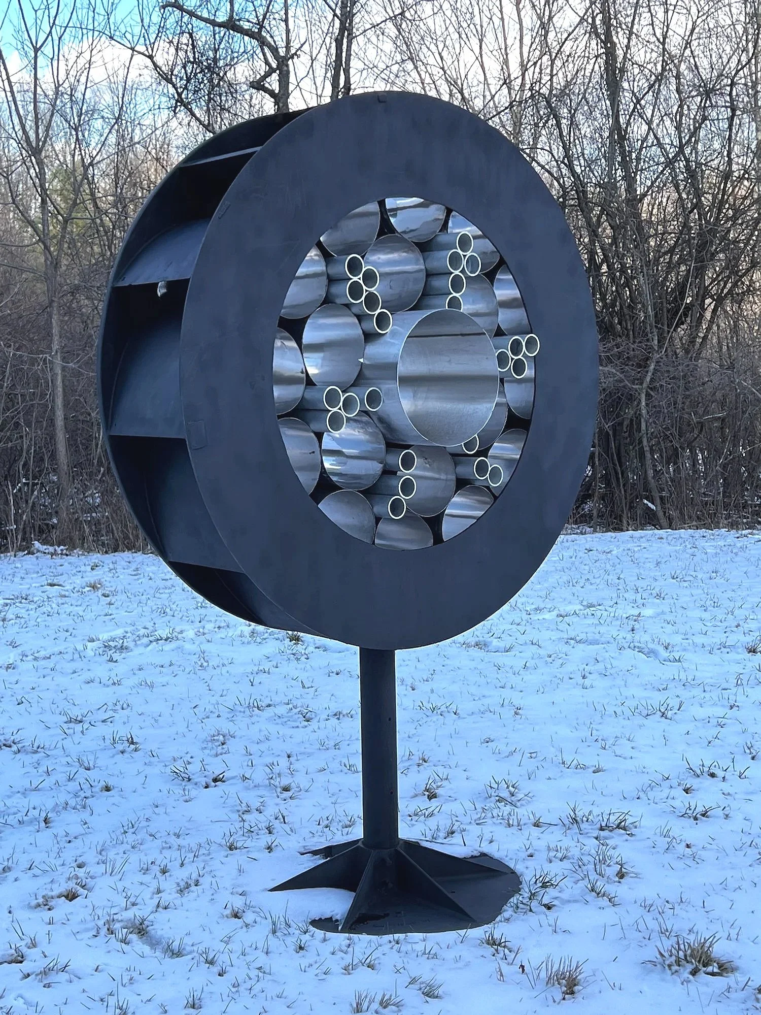 Surveillance - Inspired by the prevalence of monitoring methods that are part of our daily lives. As one drives by this piece, it appears to flicker like it’s taking a photo. Welded steel, stainless steel and aluminum cylinders. 7’5” x 5’ x 30.50”. 2