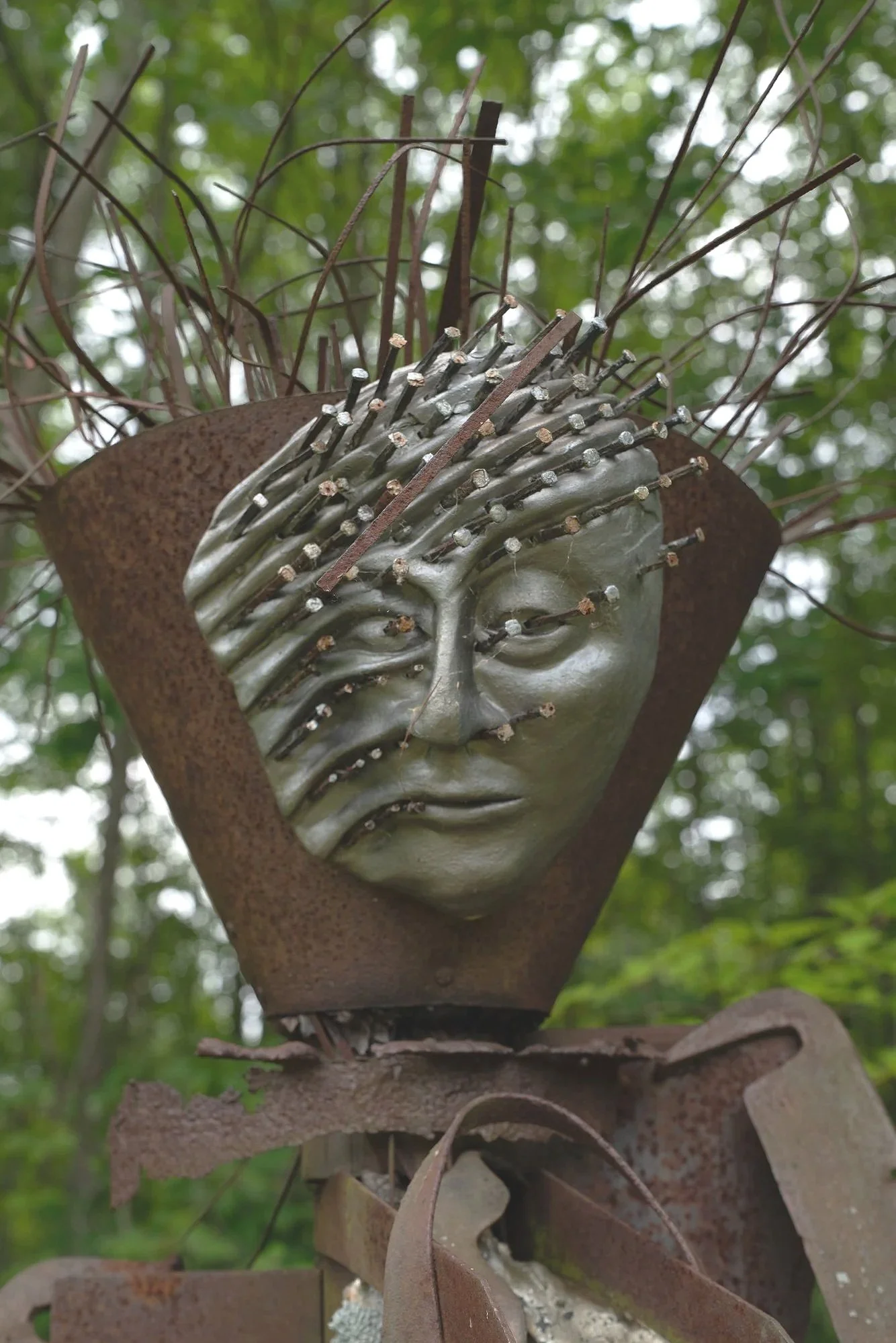 Agrarian - Inspired by the agrarian way of life in the rural upstate NY. Much of the steel in my collection has come from abandoned & outdated  farm equipment. Welded salvaged steel, modeled clay face with horse shoe nails. 8’5” x 3’ x 3’. approx. 19