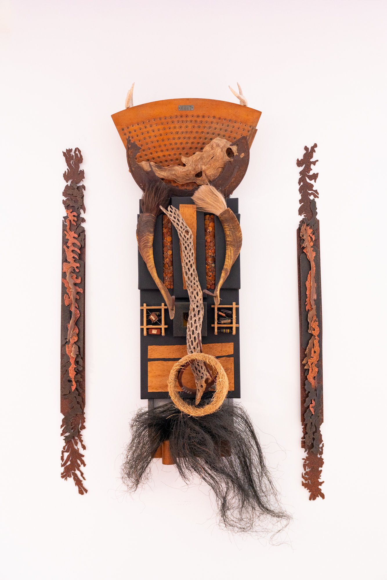 Scalped  - Inspired by the act of being severely defeated. Wood pattern pieces, grass ring, water buffalo horns & tails, antlers, wire, canvass, window screen. 60” x 32” x 8”. 2022